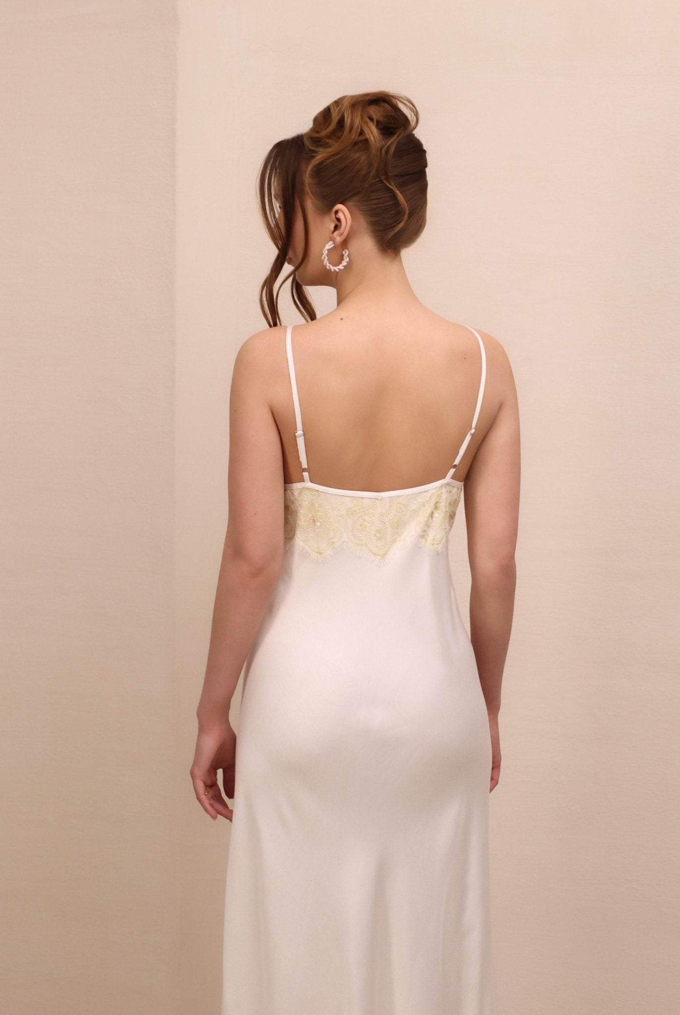 Rear view of the nightgown to the knees, illustrating the simple silhouette and the graceful fit of the garment.