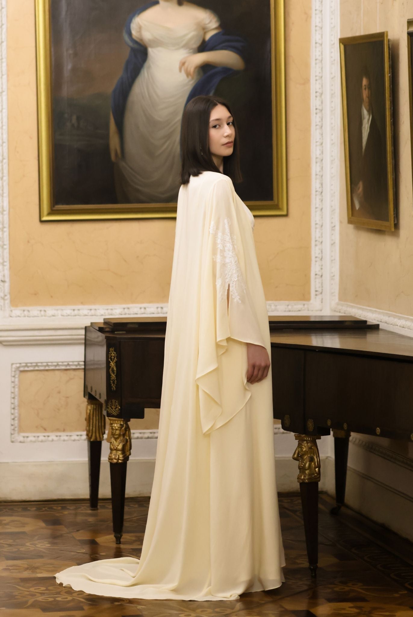 A poised shot near a piano, showcasing the Robe and Nightgown Set with its elegant and weightless long train.
