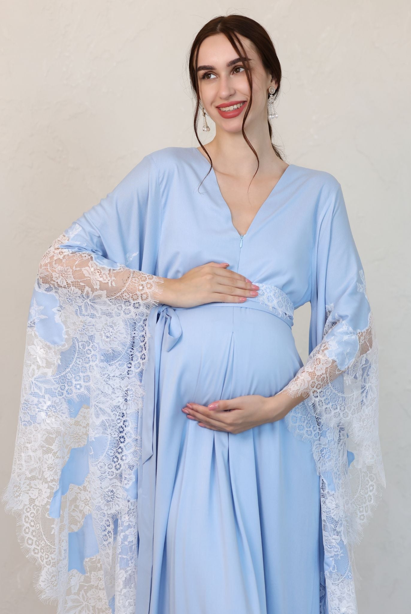 Mid-length frontal view with hands cradling the bump, highlighting the comfortable fit and hidden nursing zipper.