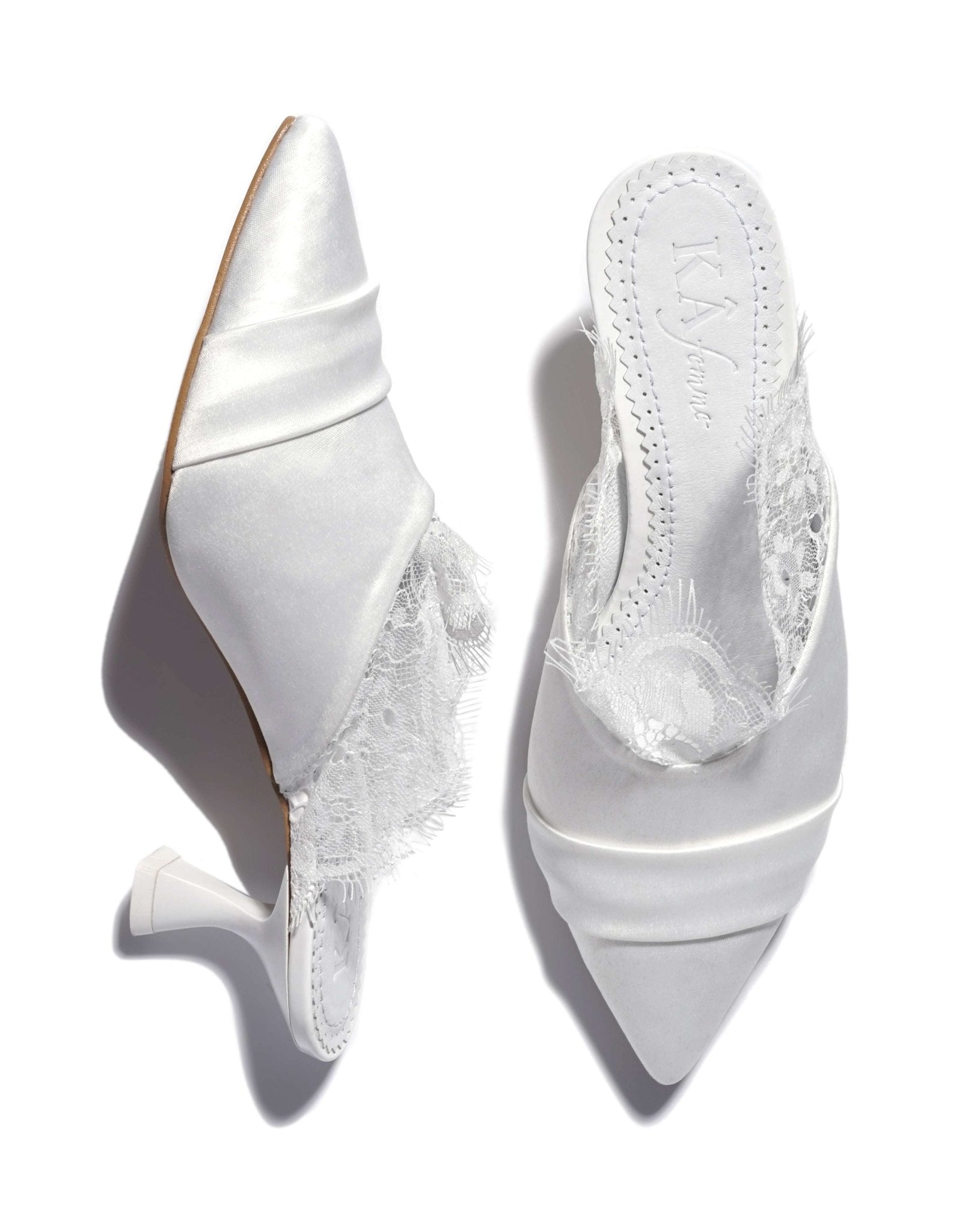 A shot of the slippers on a white background, where one shoe stands and the other lies to show the heel.