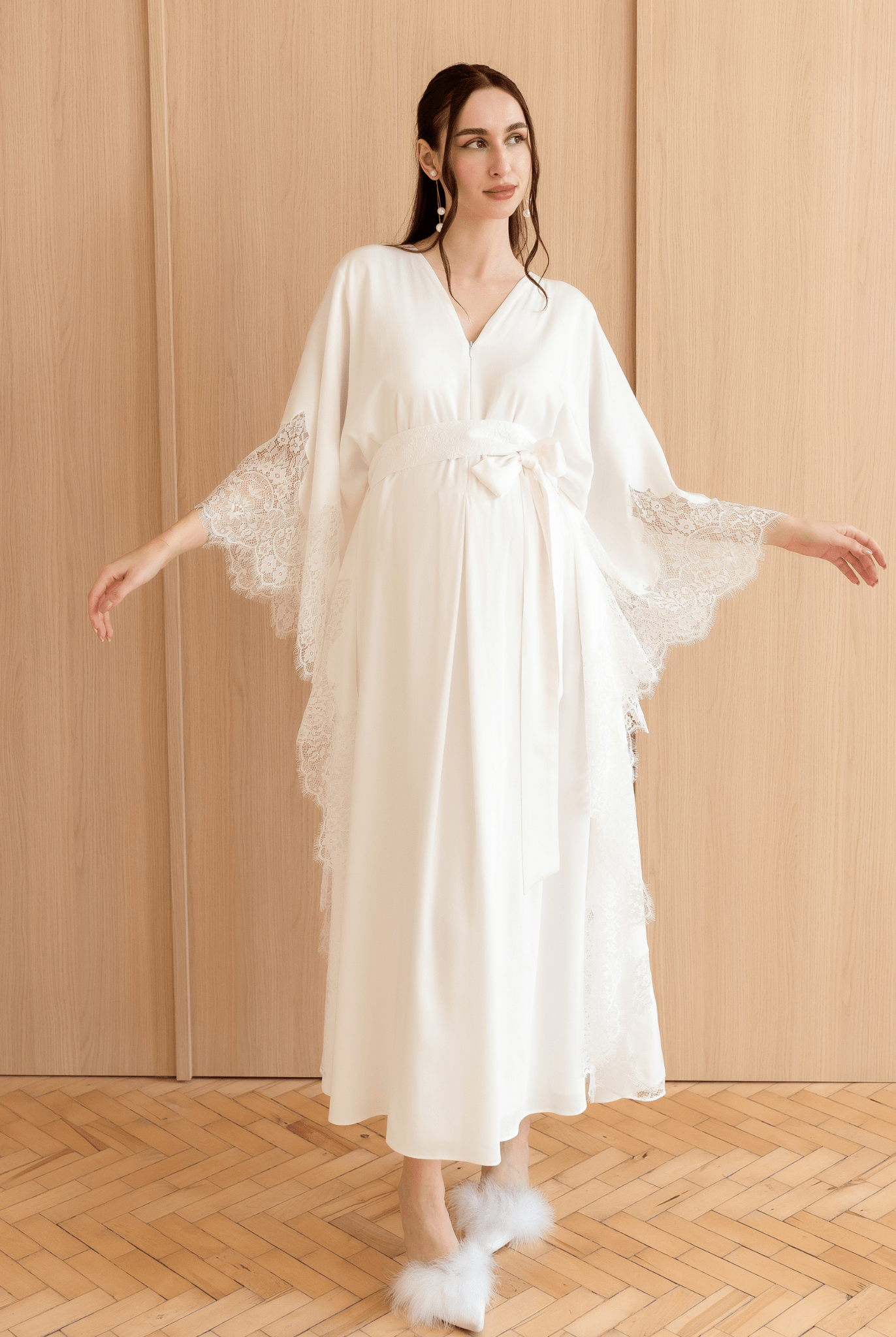 A flowing Cotton Kaftan shown in a pose with raised arms, highlighting the loose fit and decorative side lace.