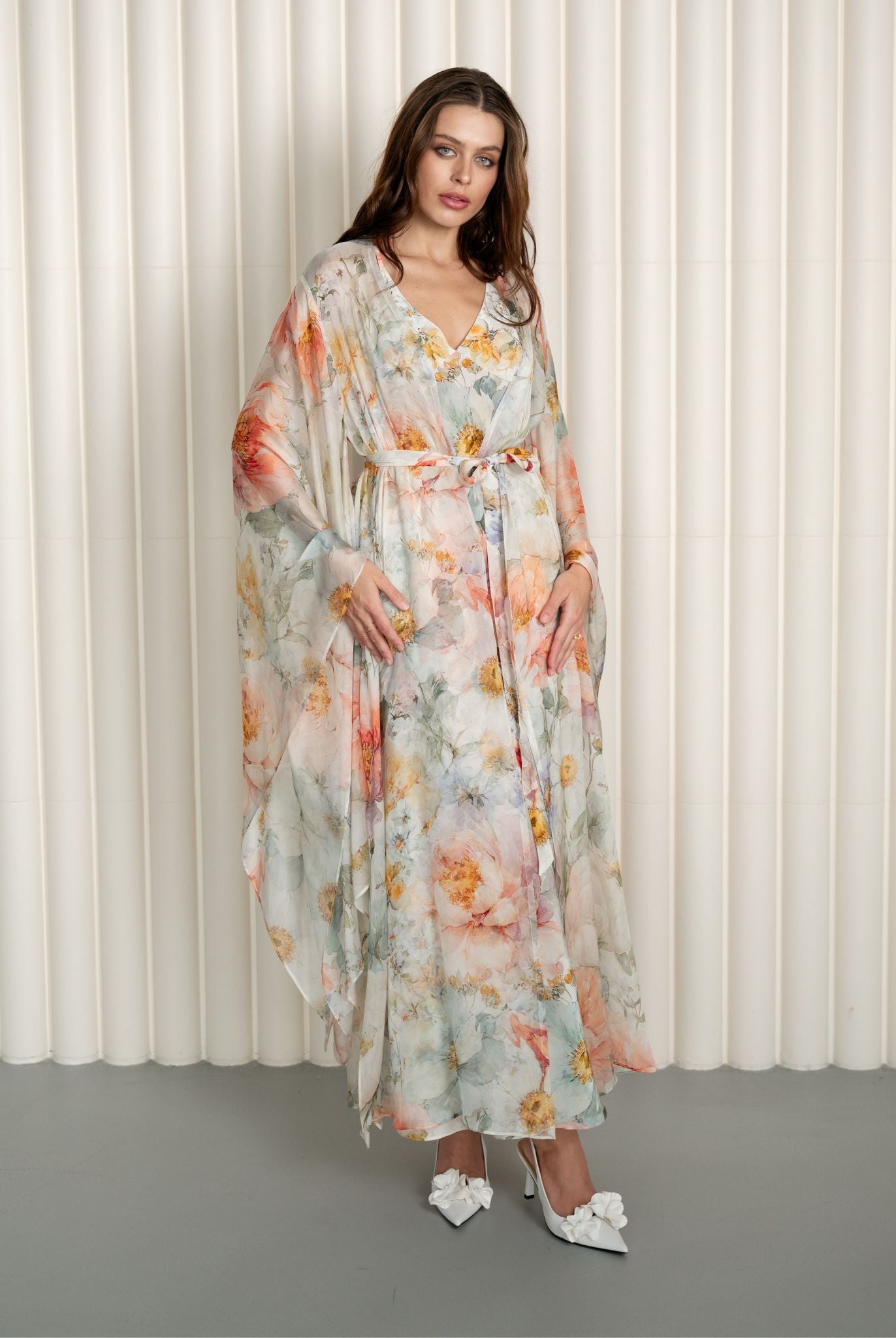 Model twirling in floral silk robe and nightgown set