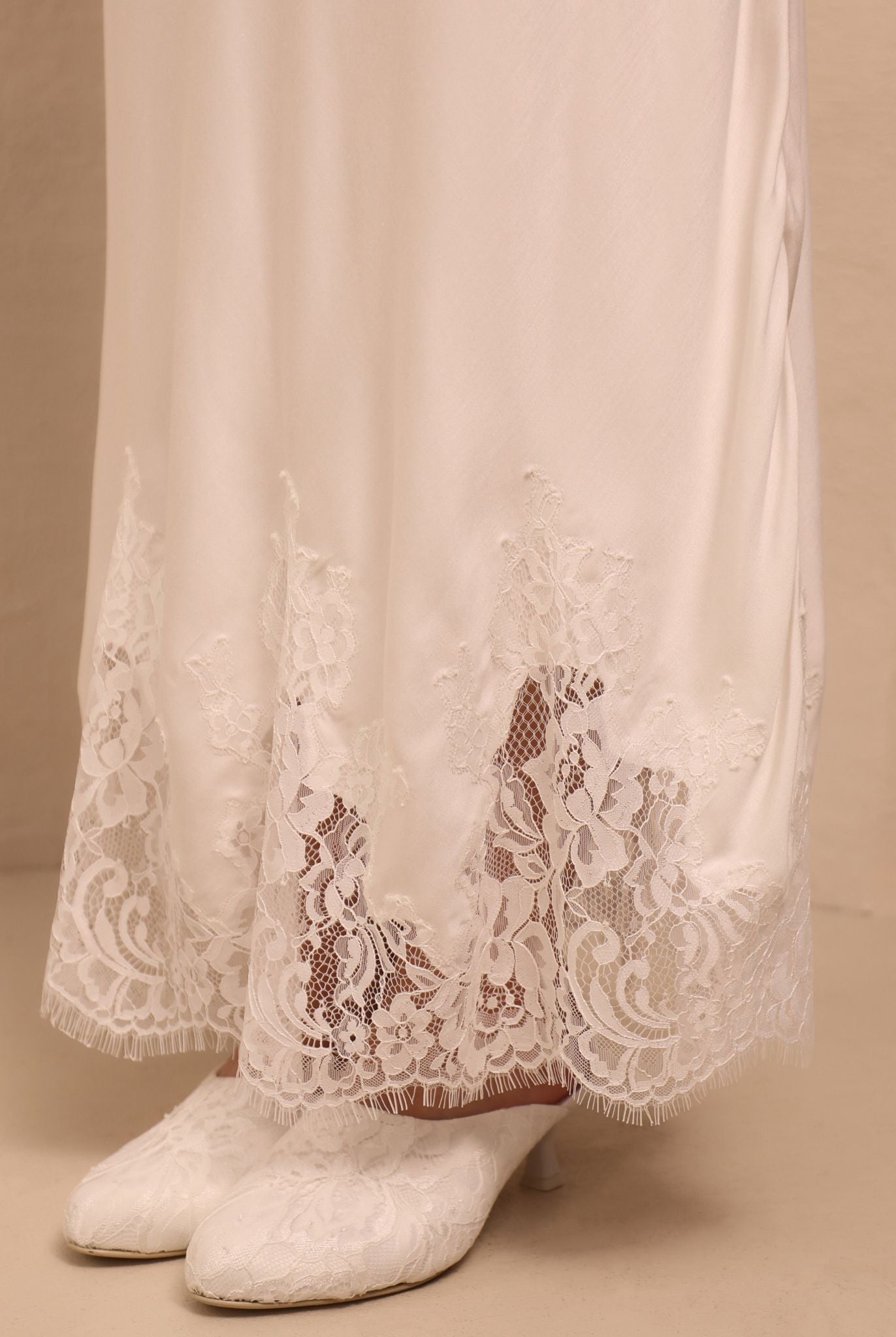 A detailed close-up of the nightgown’s hem, showcasing the smooth finish and the light texture of the fabric.