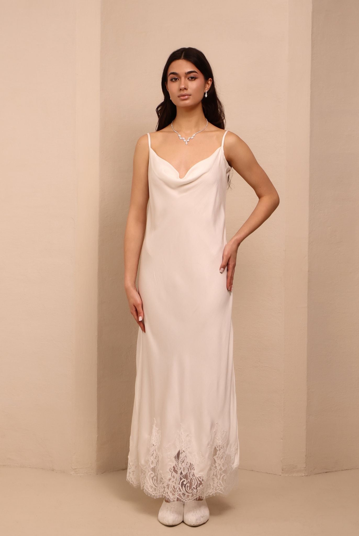 A static shot of the white nightdress, featuring a graceful neckline and delicate adjustable straps.