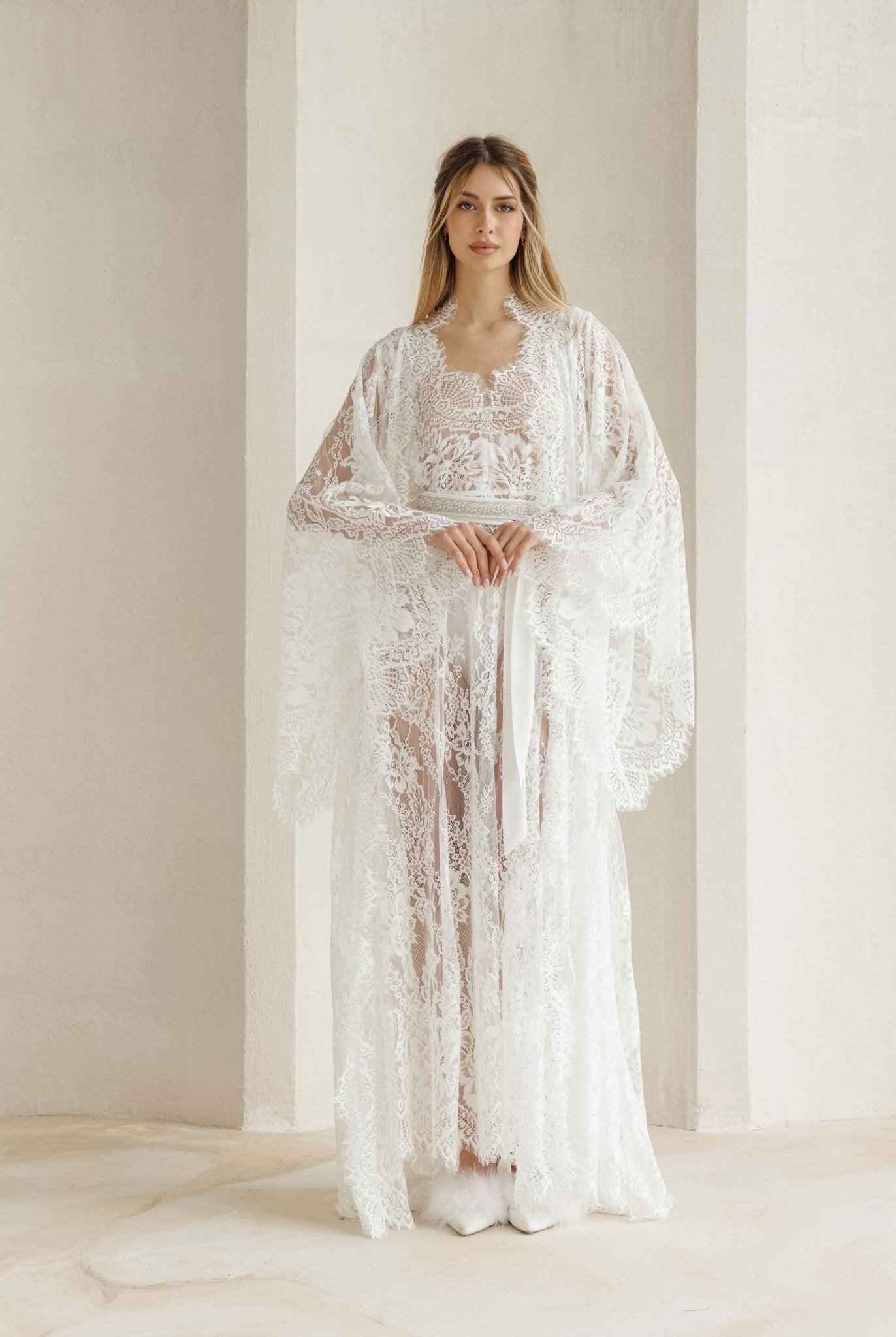 Full-length view of the lace ensemble with hands at the waist, highlighting the refined and light silhouette.