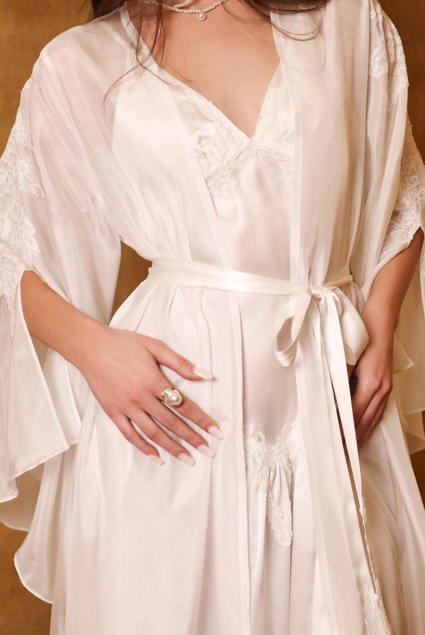 Detailed shot of the belted robe, focusing on the silk tie and the exquisite craftsmanship of the lace-trimmed sleeves.