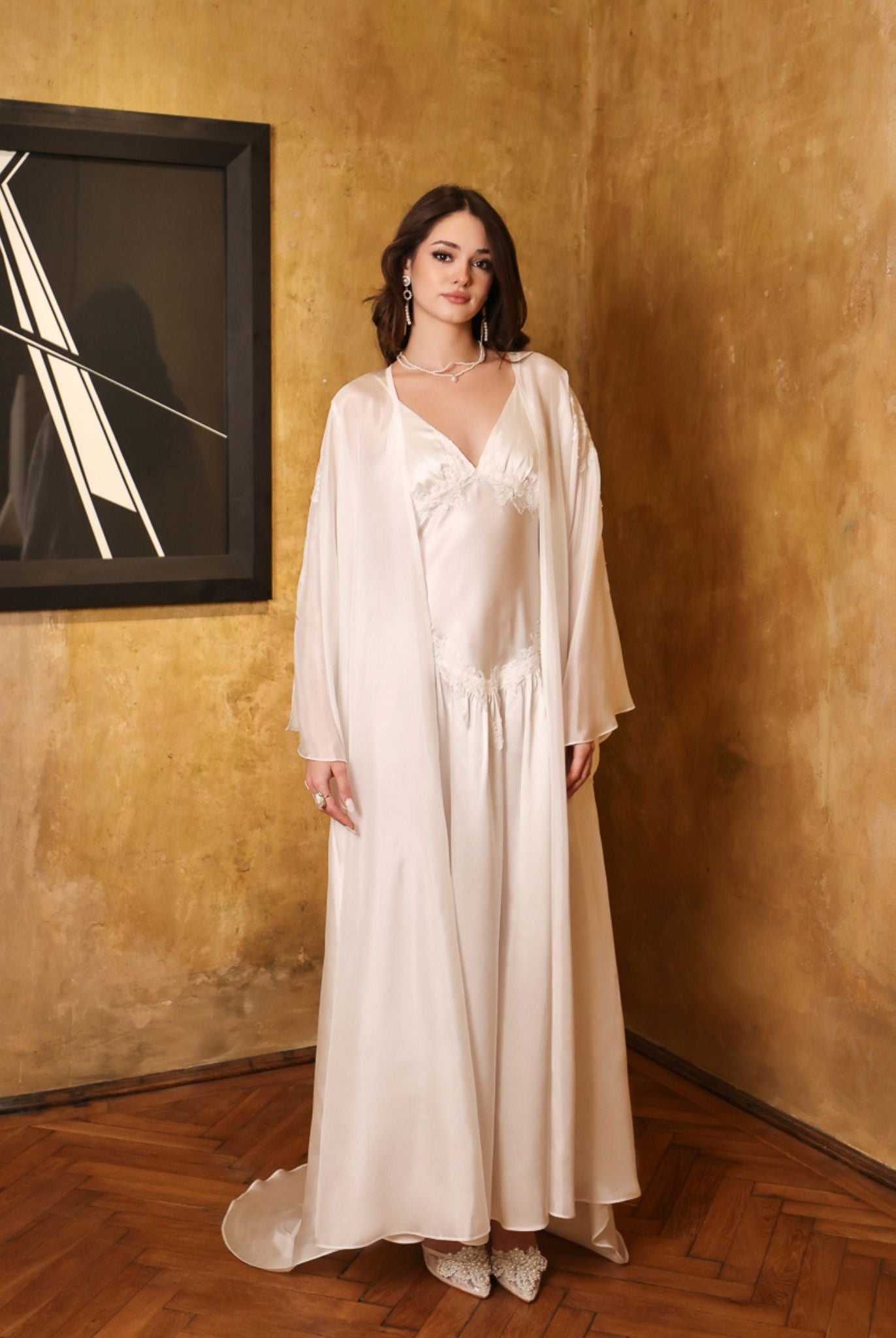 Elegant pose in the complete silk set with a raised hand, capturing the play of light on the sheer chiffon layers.