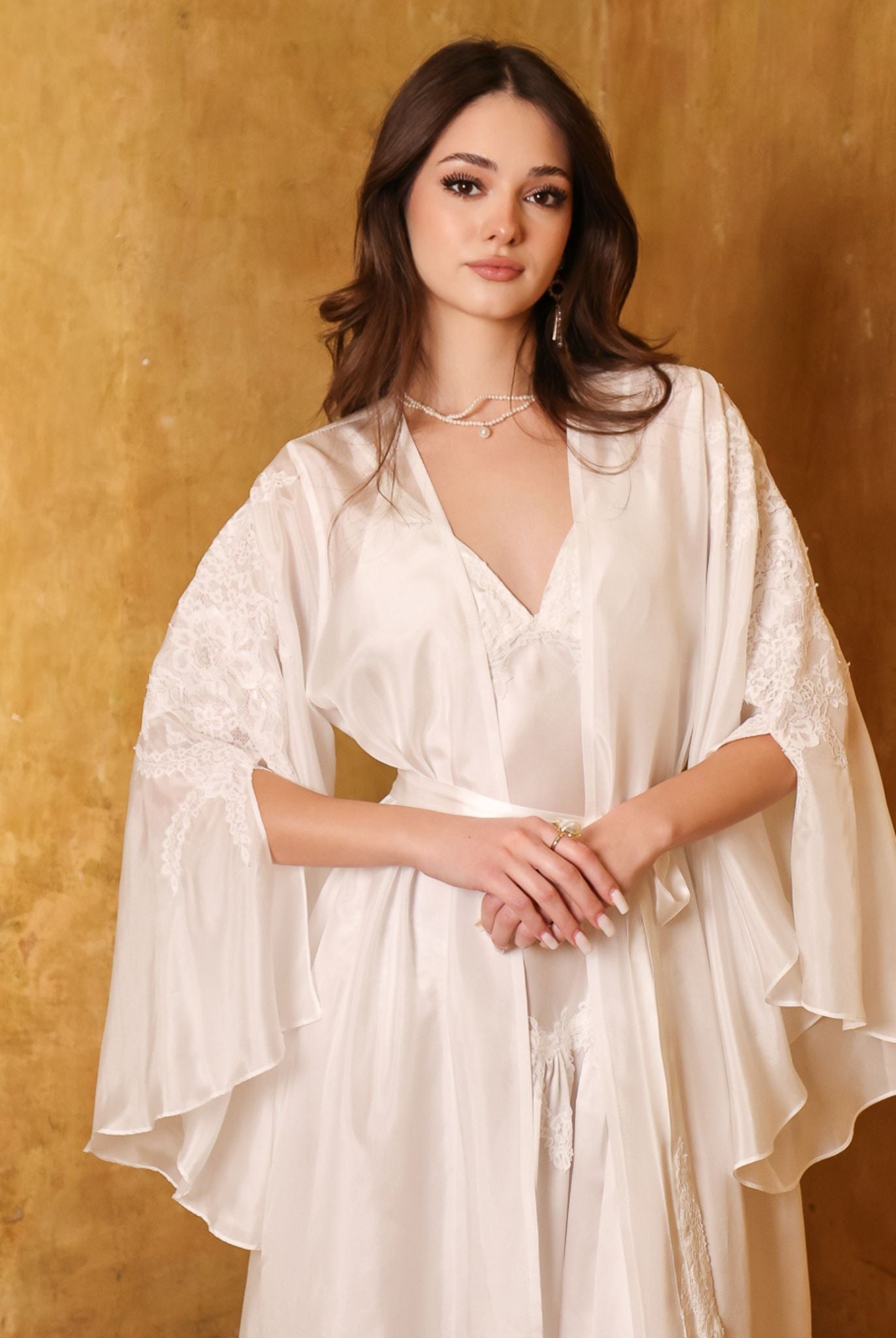 Portrait-focused shot of the bridal ensemble, showcasing the refined lace embellished sleeves and soft silk texture.