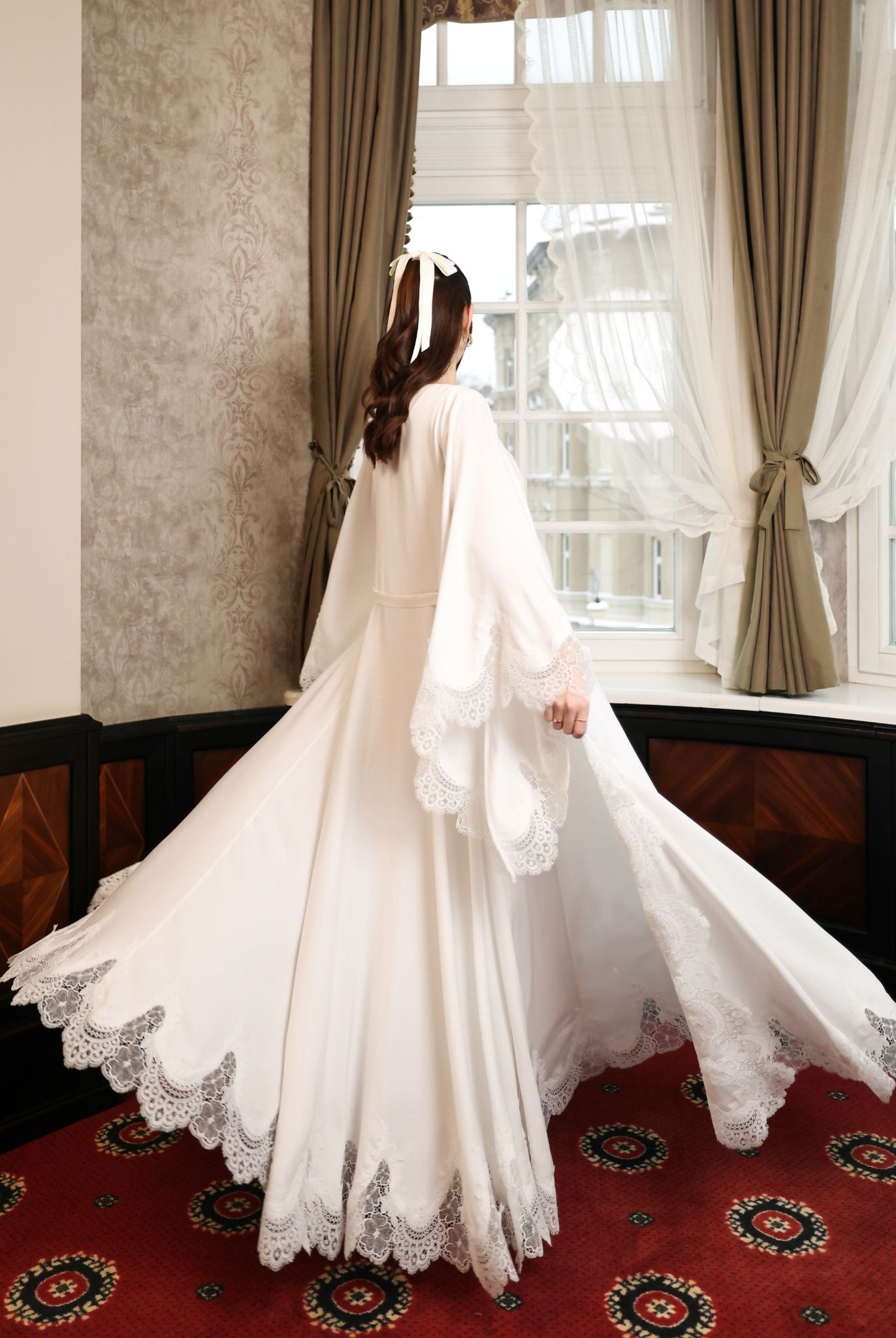 Dynamic rear view of the floor-length robe, highlighting the sweeping scalloped lace edges and soft cotton fabric.
