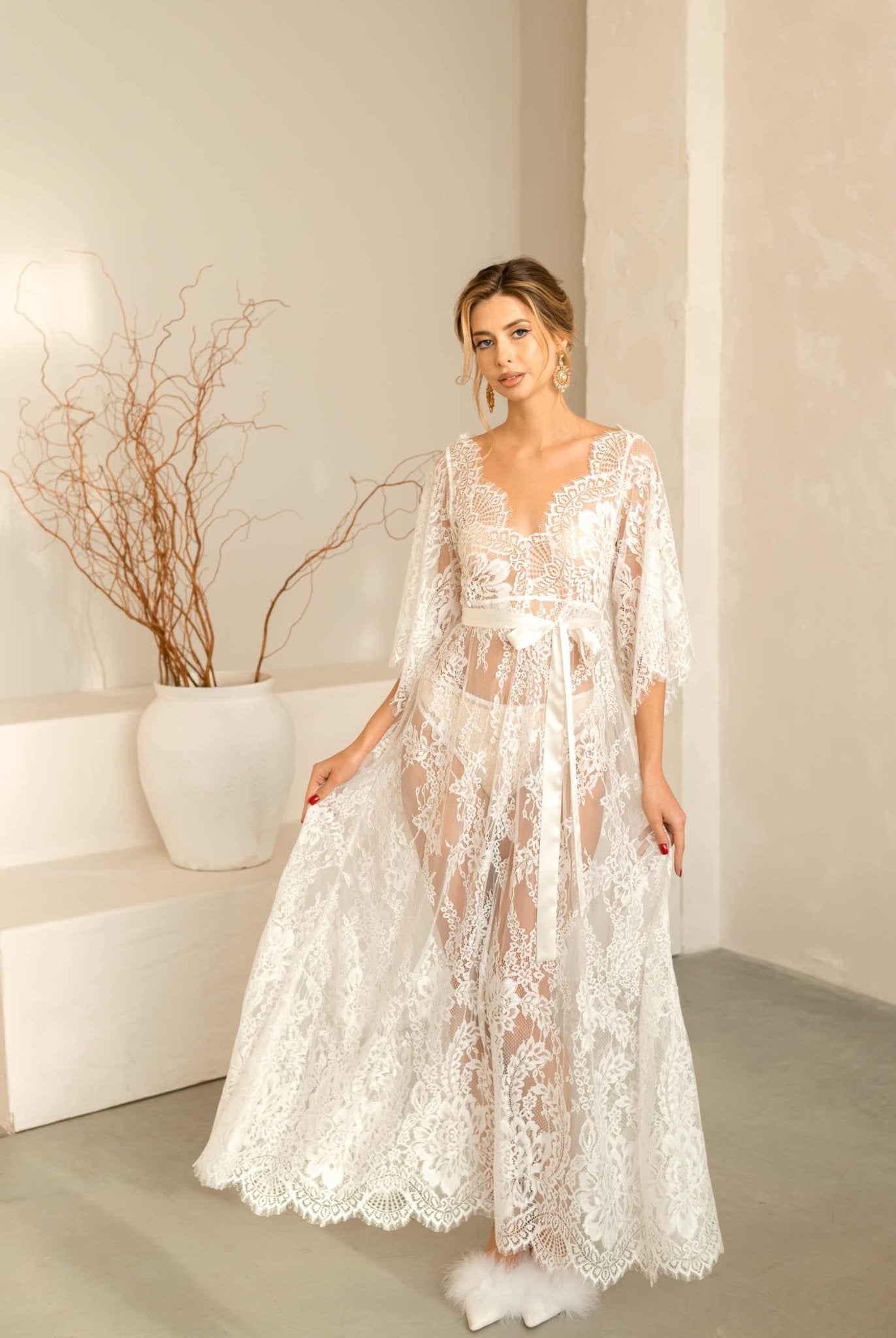 A shot of the Flora lace nightdress with the model lifting the hem to show the flowing, airy fabric.