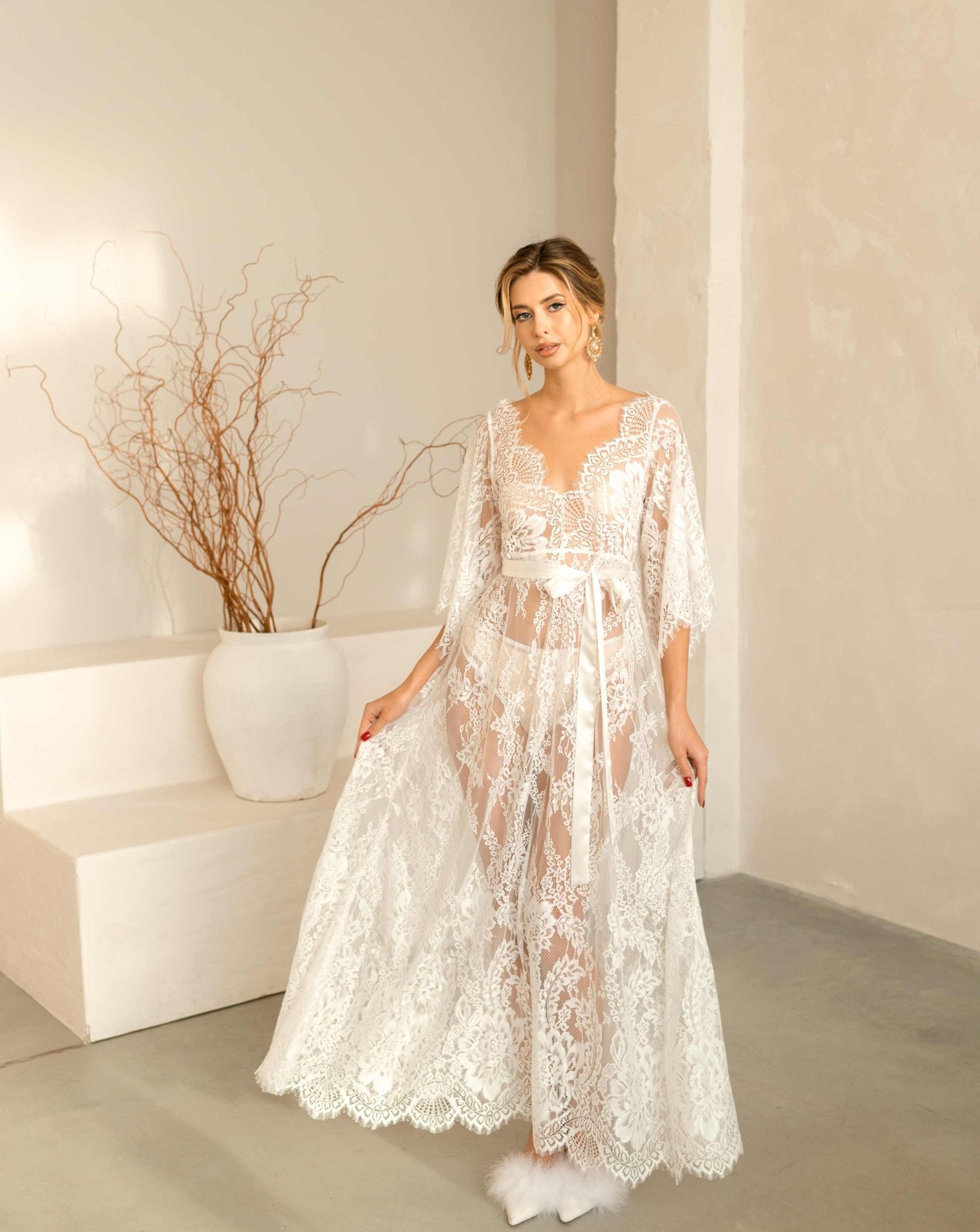 A shot of the Flora lace nightdress with the model lifting the hem to show the flowing, airy fabric.
