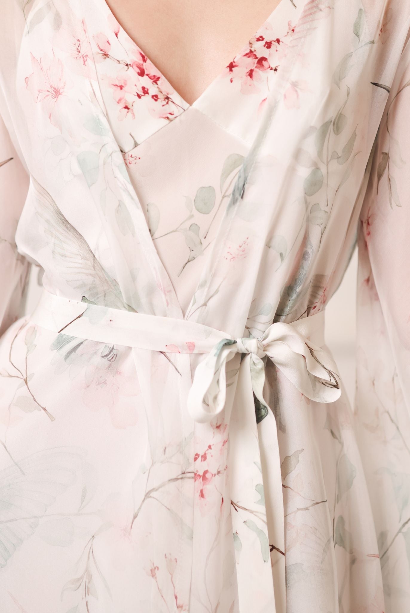 Close-up of a tied silk waist belt, focusing on the refined texture of the fabric and the floral design.