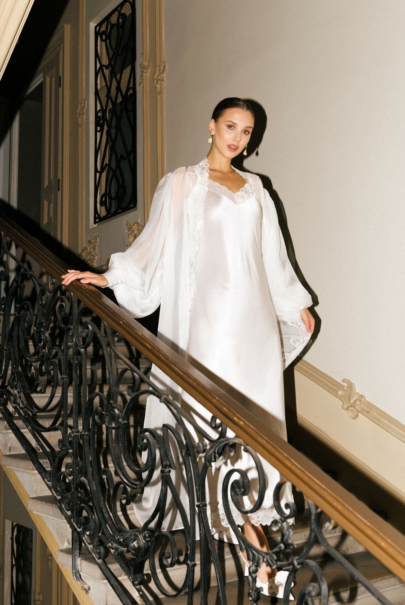 Silk Robe and Nightgown Set in motion on a staircase, capturing the weightless movement of the 100% mulberry silk.