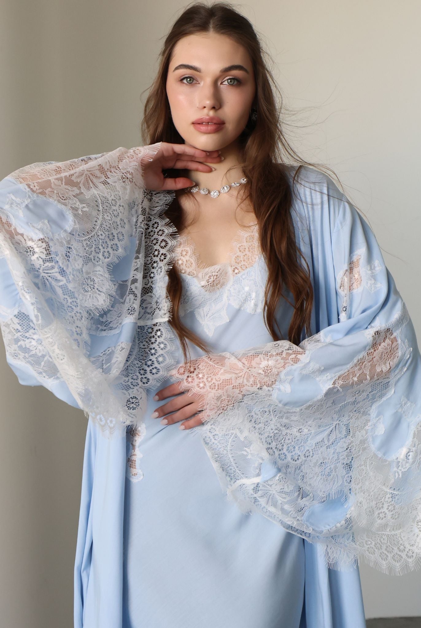 A mid-length shot focusing on the exquisite lace detailing and the elegant wide sleeves of the robe.