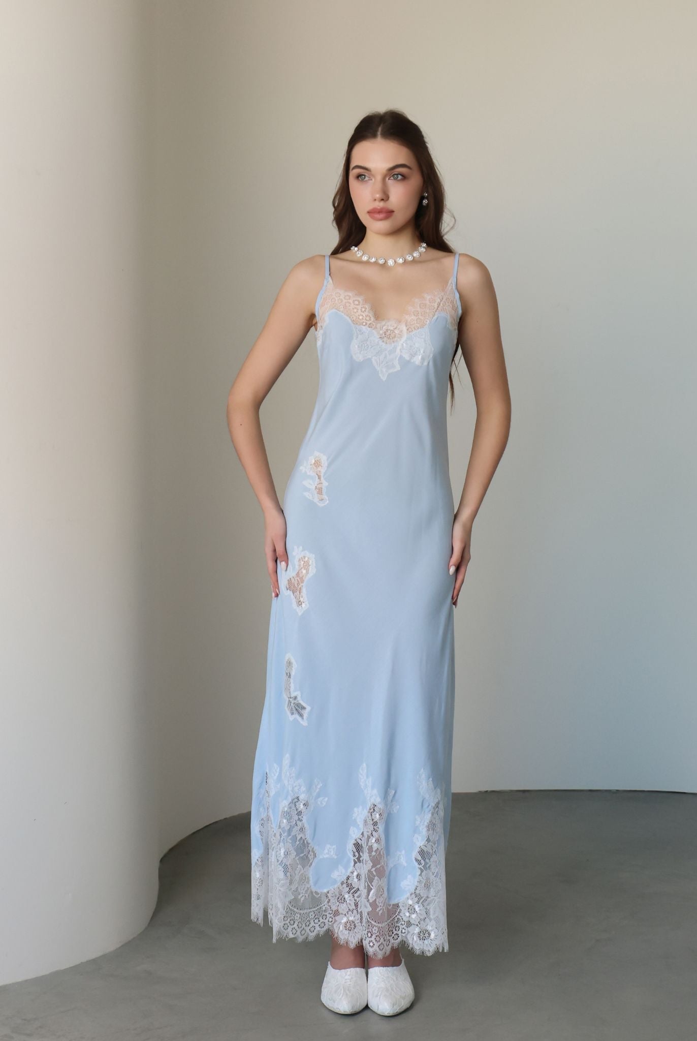 Frontal view of the nightgown adorned with delicate lace cutouts that trace the silhouette with artistic charm.