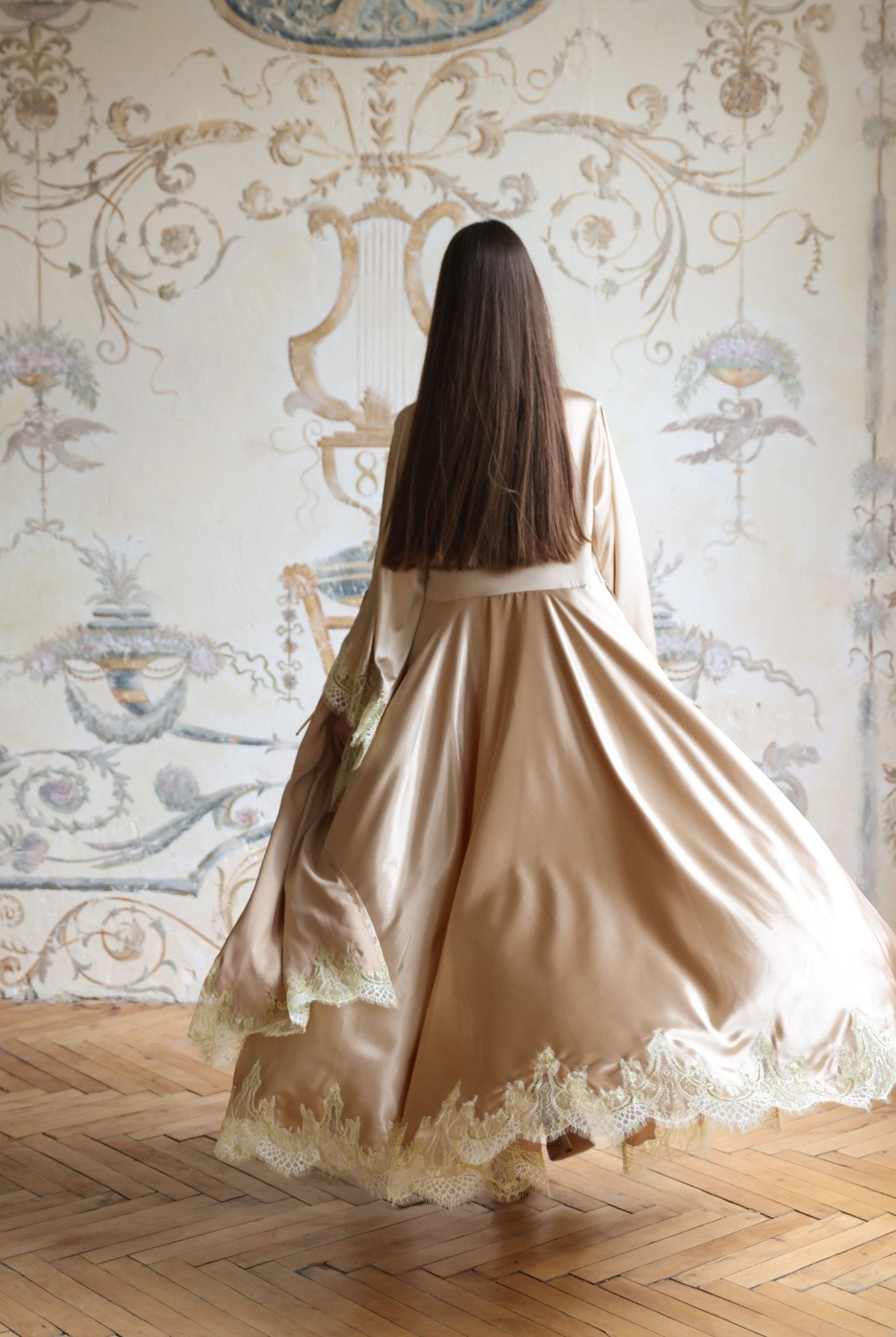 Rear view of the flowing robe in motion, showcasing the wide sleeves and the elegant drape of the satin.