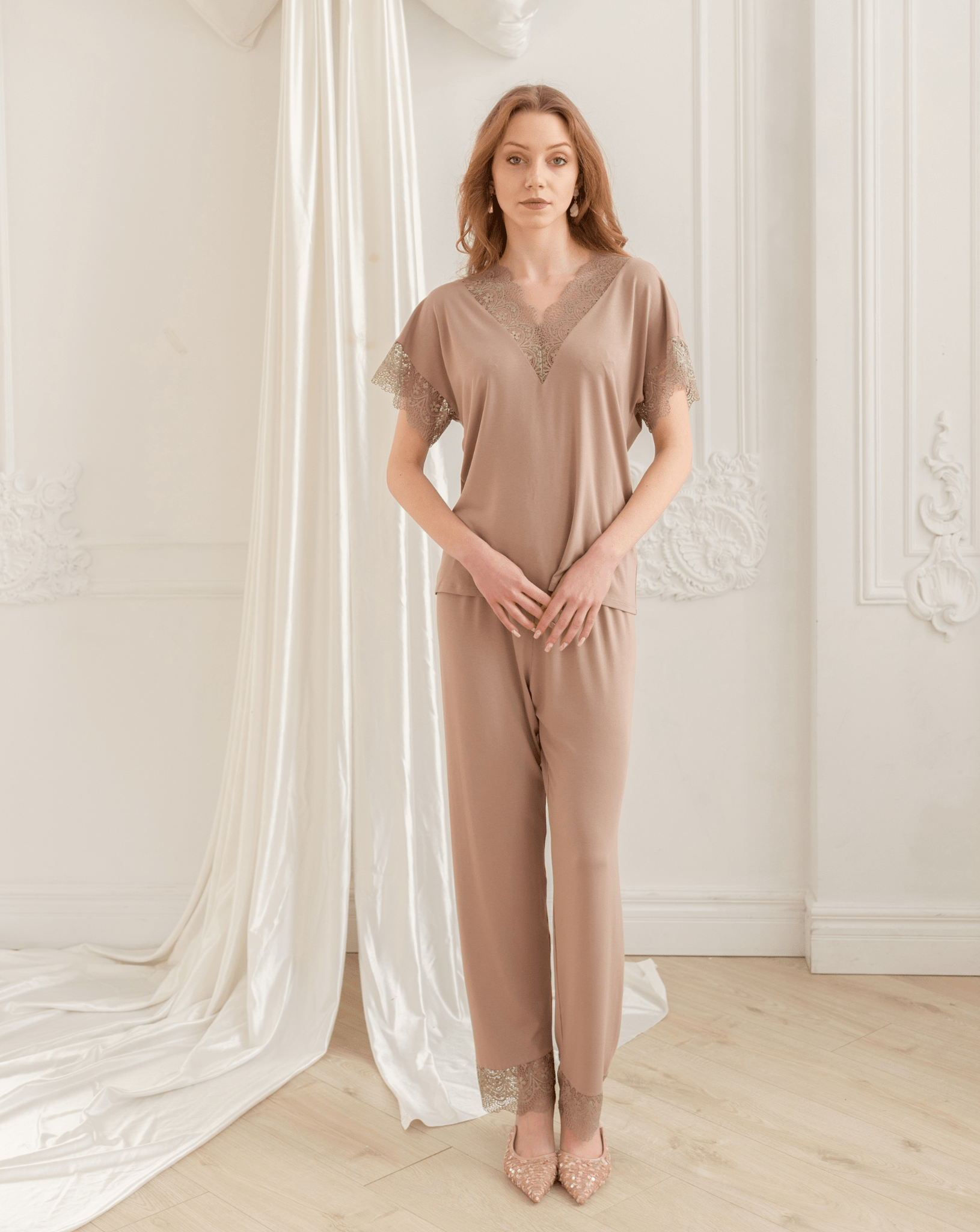 A full-length pose with hands on the hips, displaying the matching pants with a waist ribbon for effortless comfort.