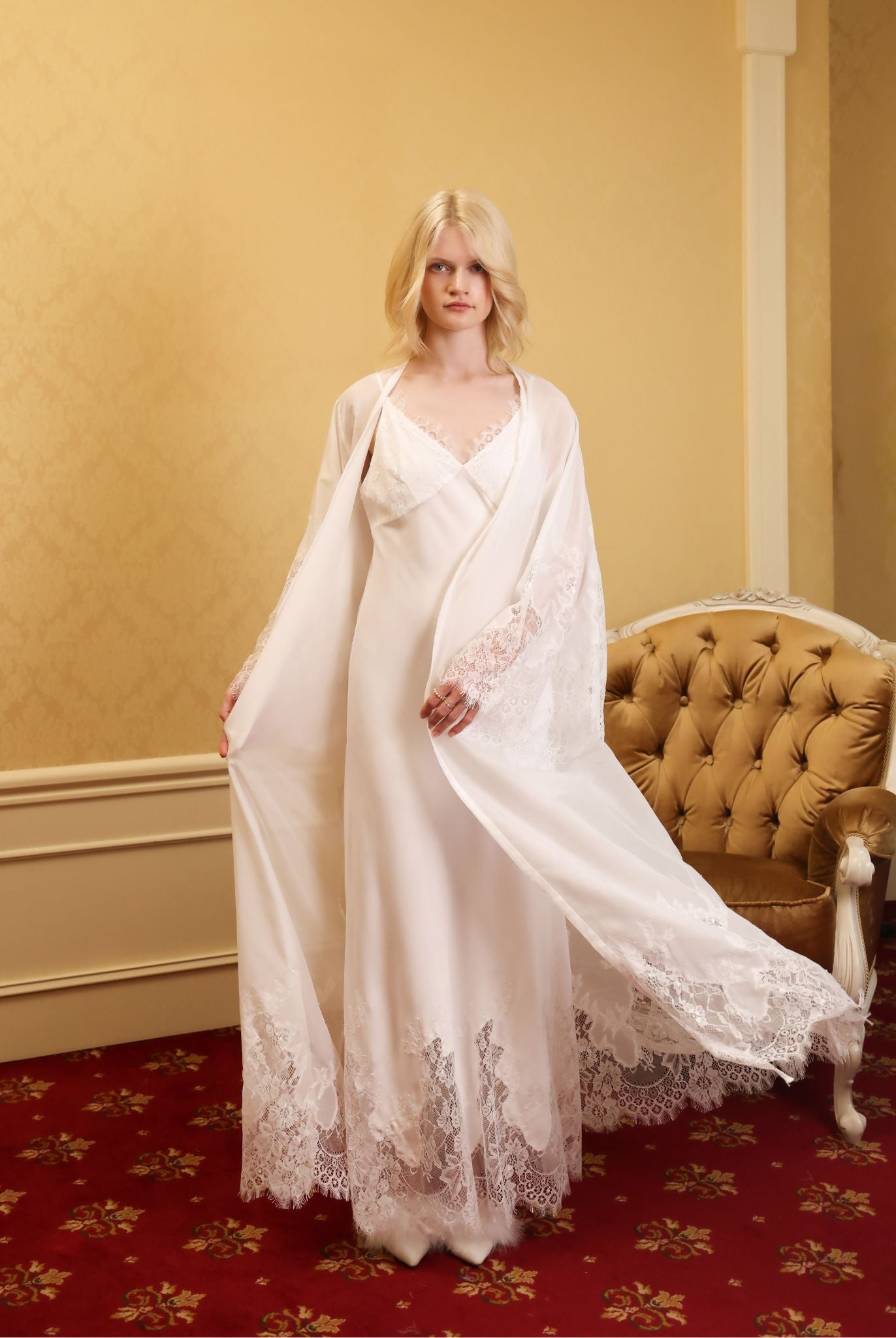 Full-length shot in a classic room, featuring the airy white robe with a flowing hem in a dynamic motion.