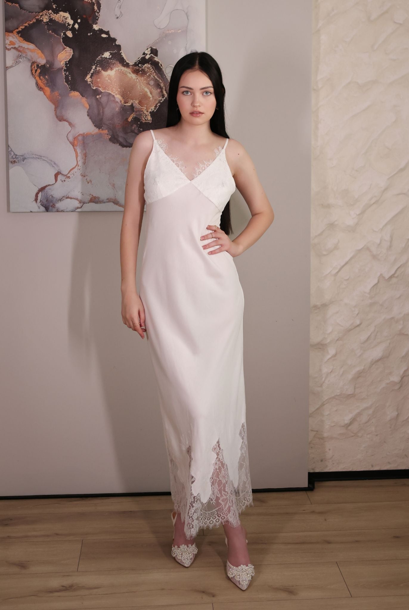 Front view of the cotton nightgown with a hand on the waist, showing the V-neckline and fine lace trim details.