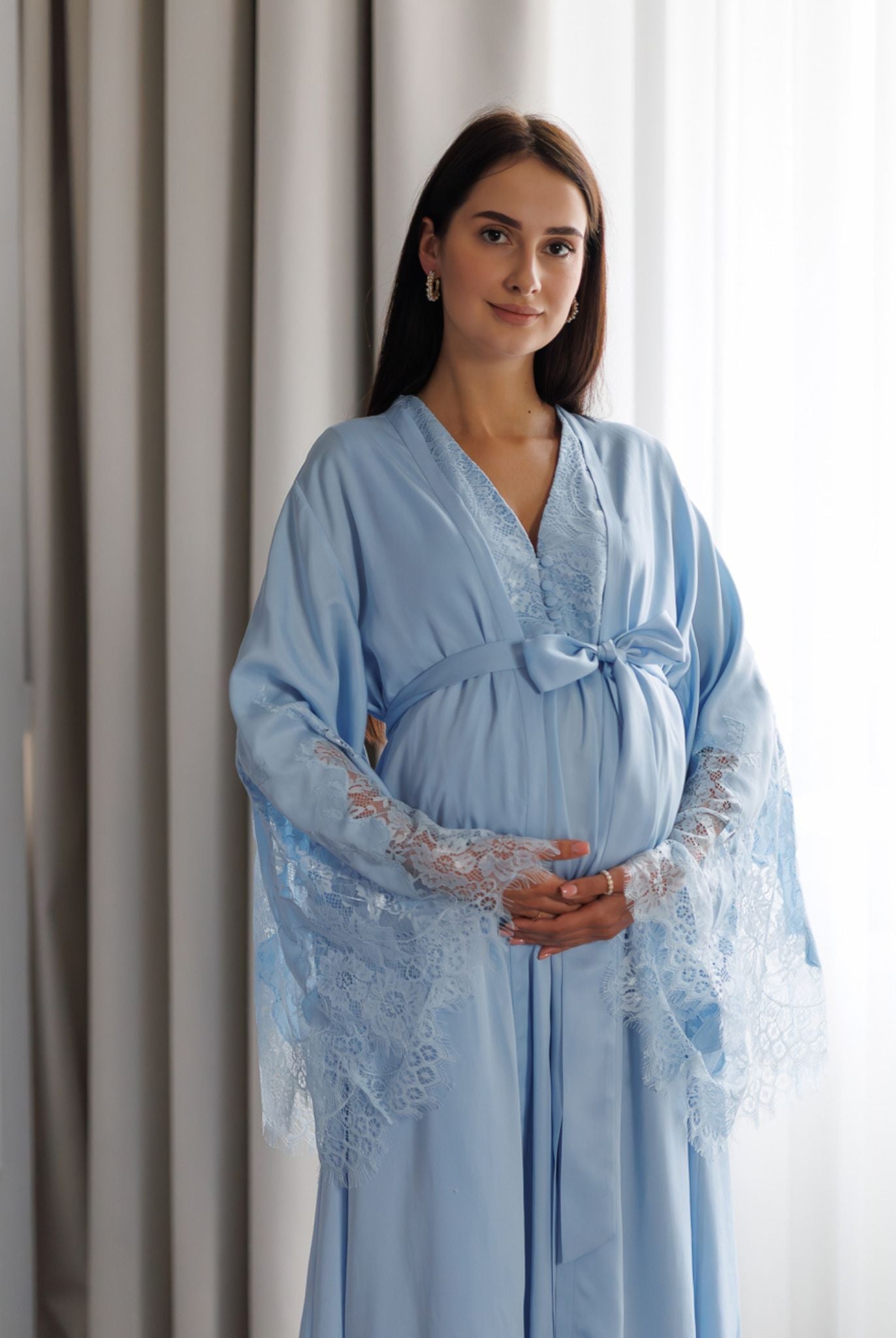 Pregnant woman wearing blue lace-trimmed maternity robe and nightgown set by Kafemme
