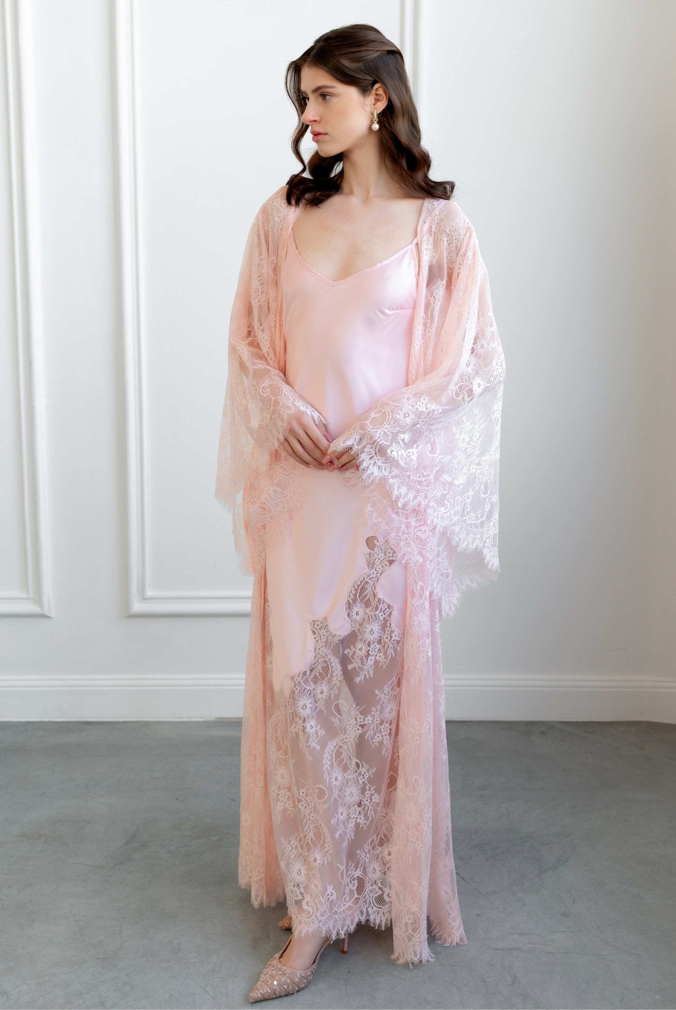 Bridal model in sheer pink lace set standing in minimalist white room