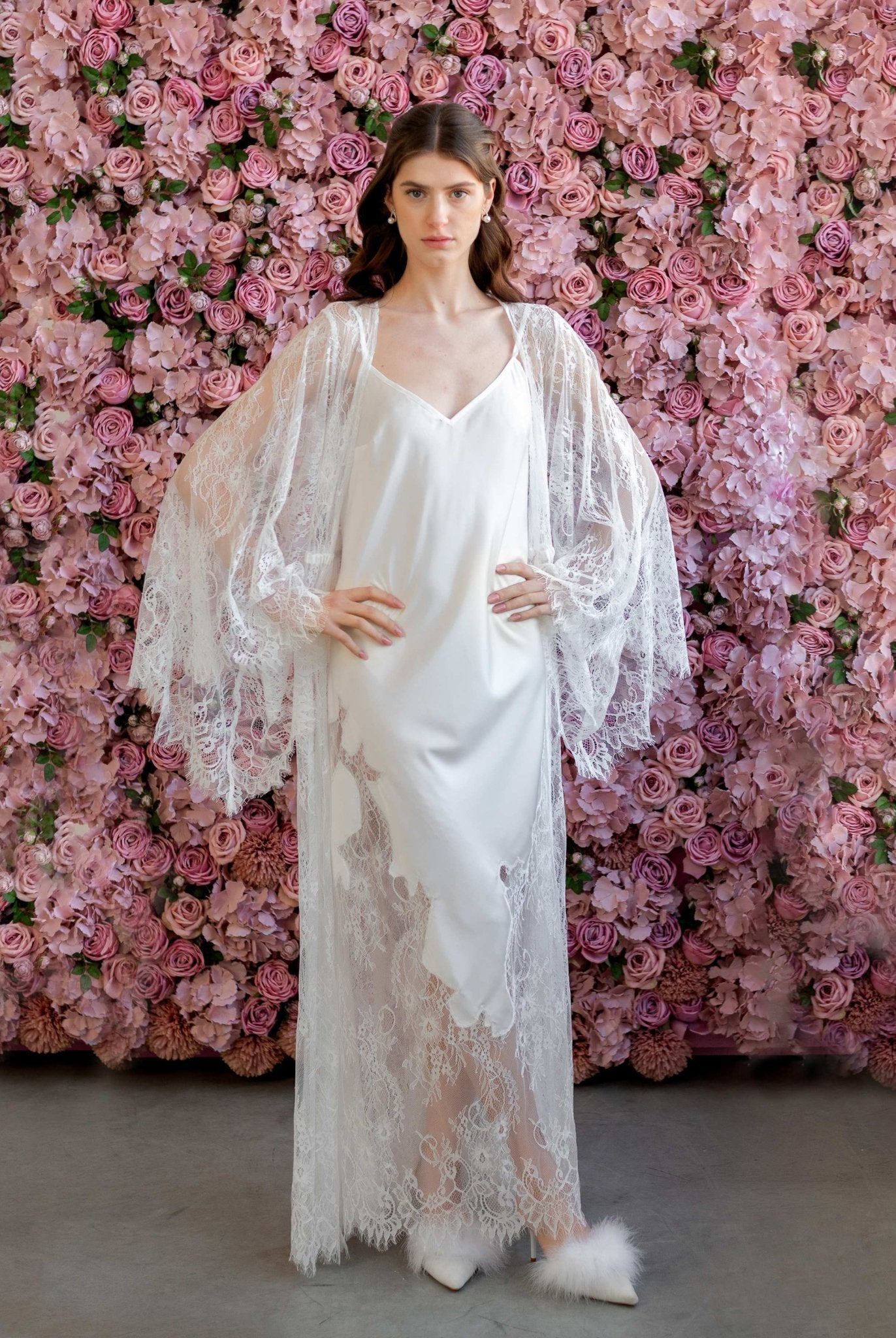 Elegant bridal model in sheer embroidered robe and white satin gown, floral backdrop - Kafemme Loungewear