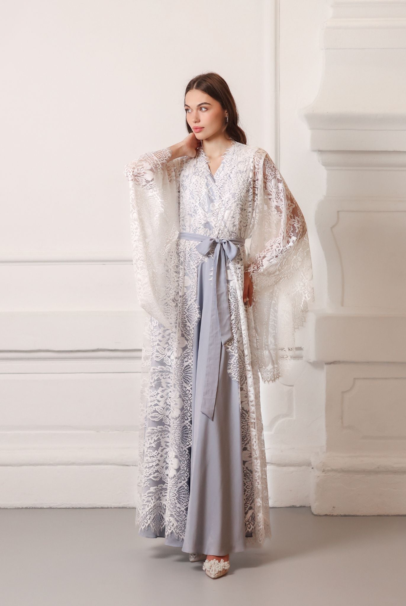 The maternity robe and nightgown set in a tied look, with one hand on the hips and the other near the neck.