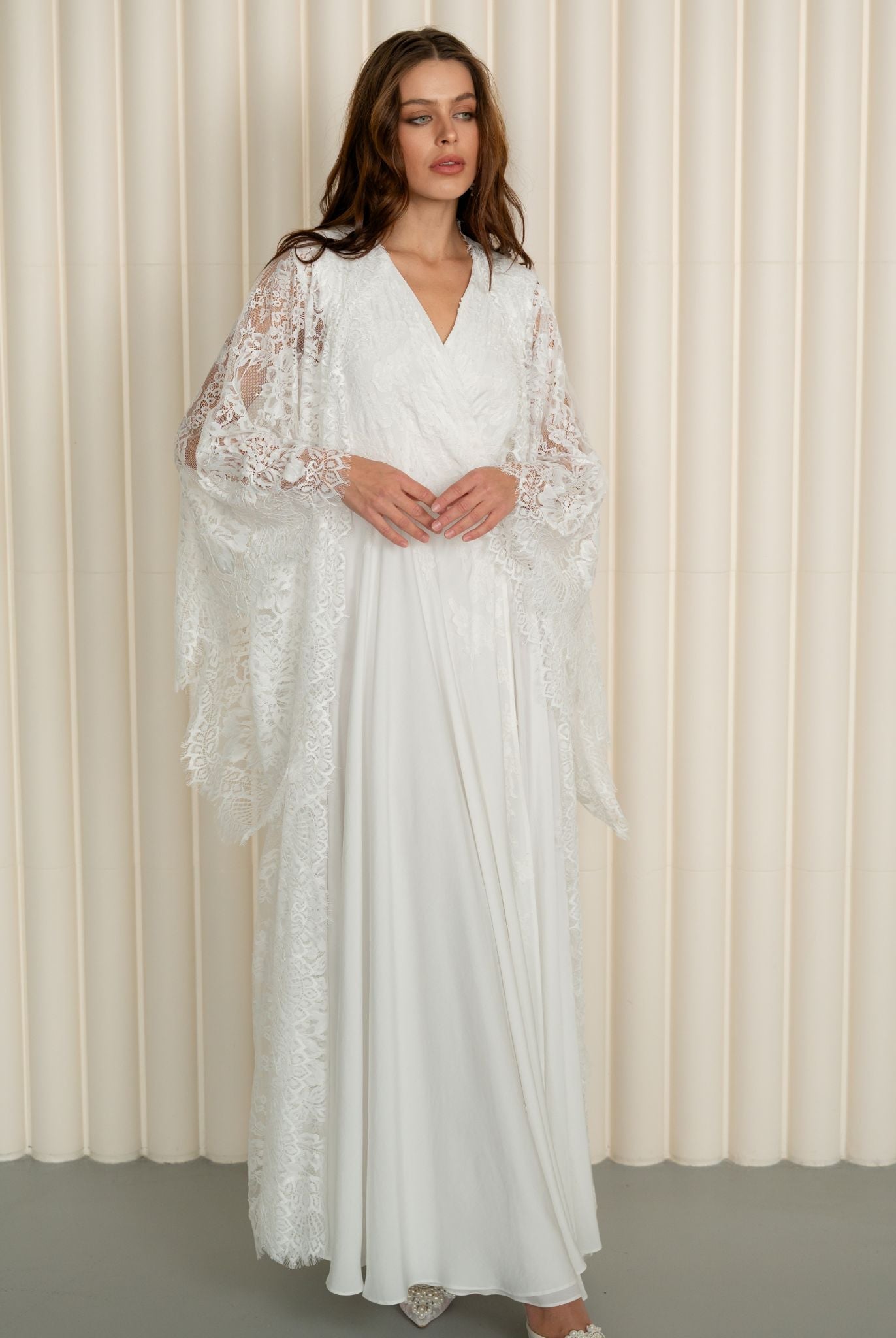 A static shot of the maternity robe and nightgown set with the woman's hands gently resting on her belly.