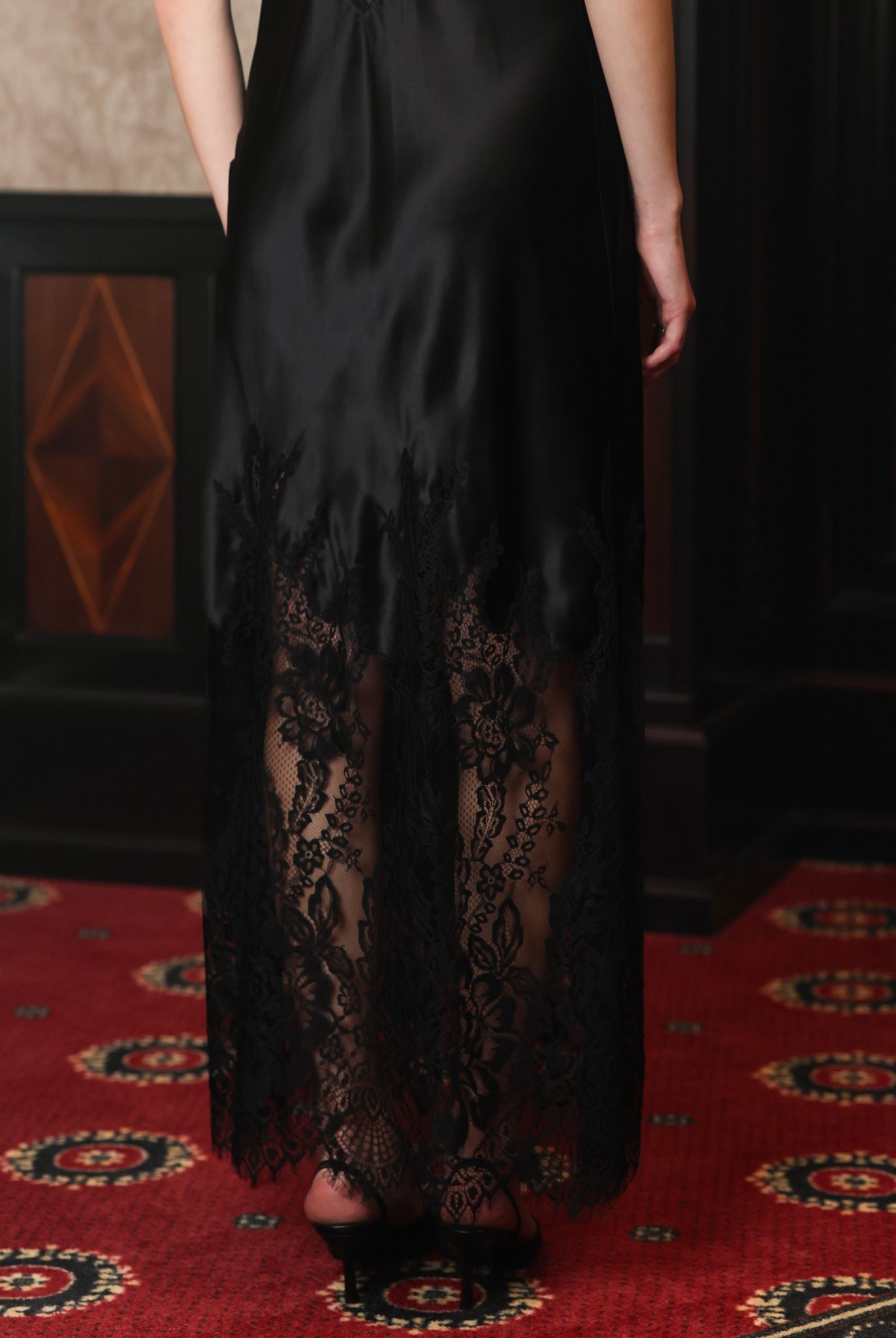 Detailed shot from the waist down, focusing on the visual contrast of the lace-trimmed hem and silk fabric.