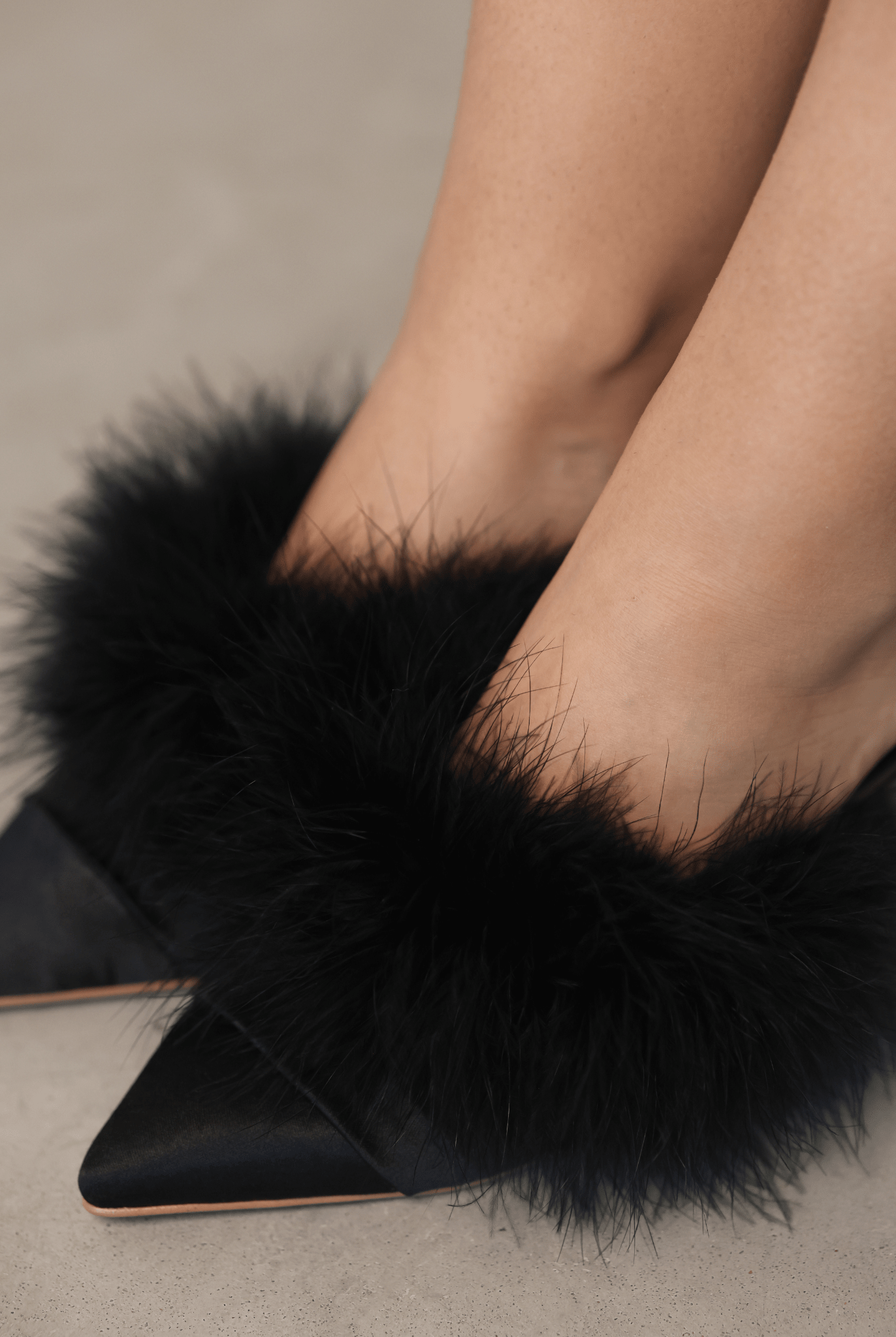 A top-down view of the elegant footwear on the feet, showcasing the plush texture and feminine finish.