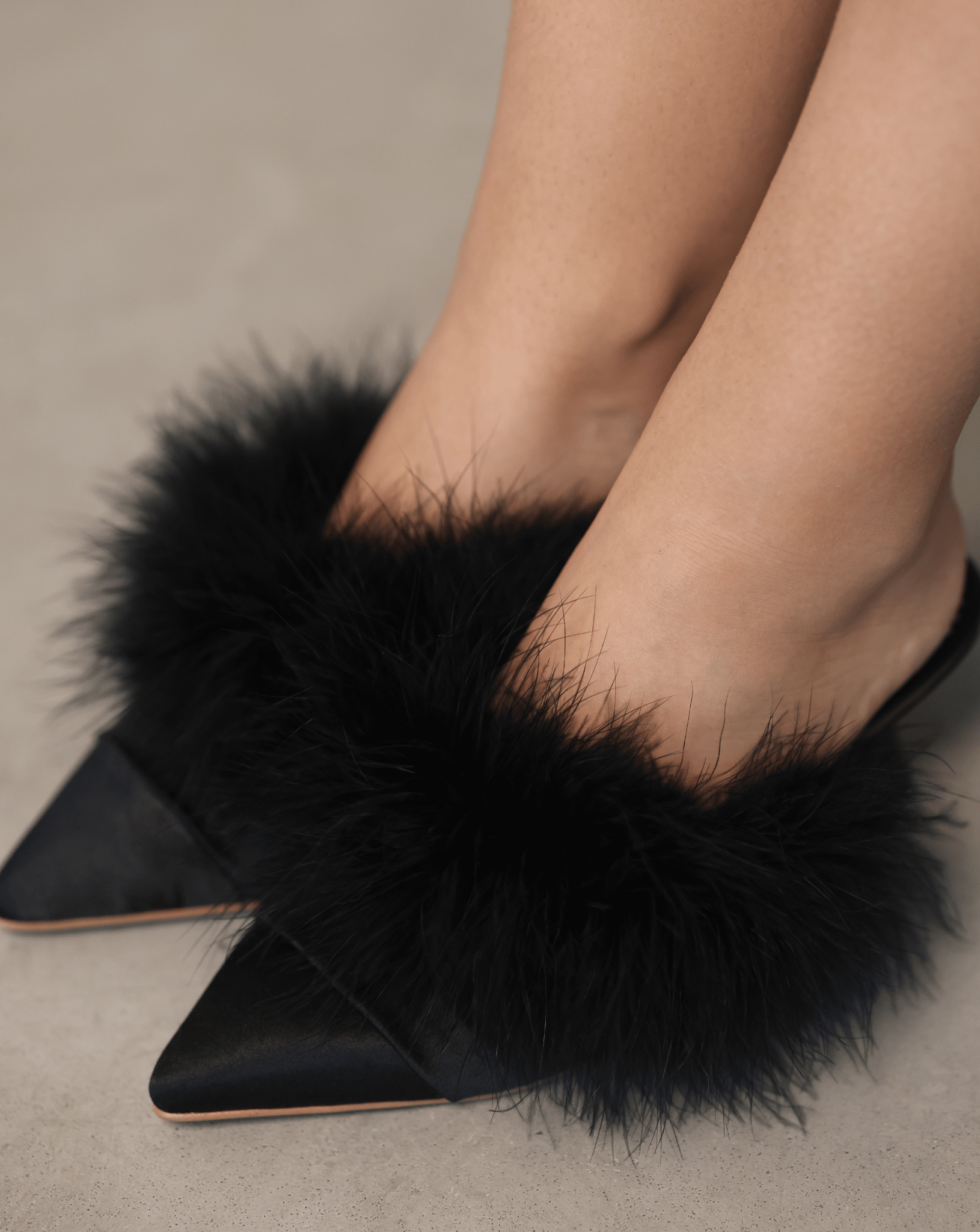 A top-down view of the elegant footwear on the feet, showcasing the plush texture and feminine finish.