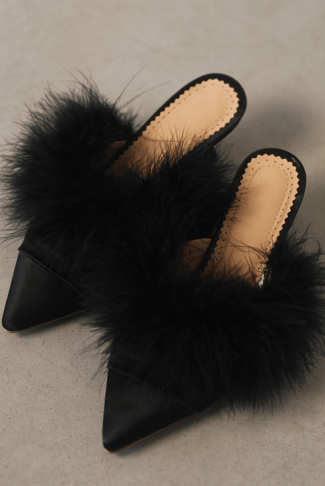 A wide top-down shot of the mules on the floor, illustrating the slim silhouette and stable base.