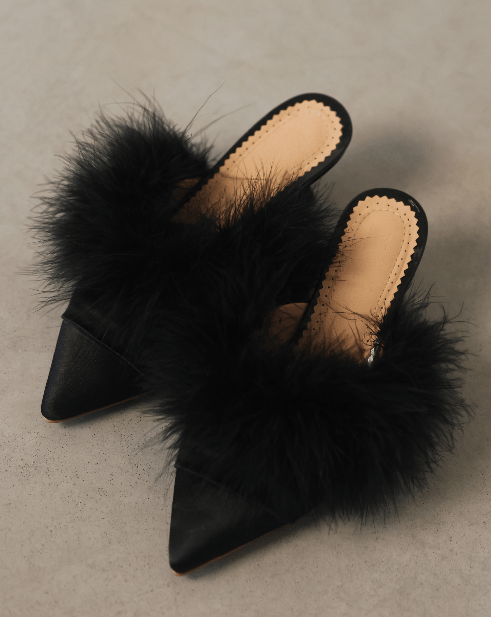 A wide top-down shot of the mules on the floor, illustrating the slim silhouette and stable base.