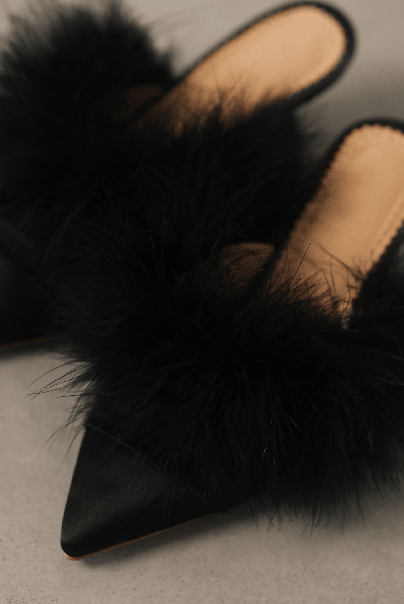 A close-up top view of the Satin Slippers on the ground, focusing on the satin base and feather adornment.