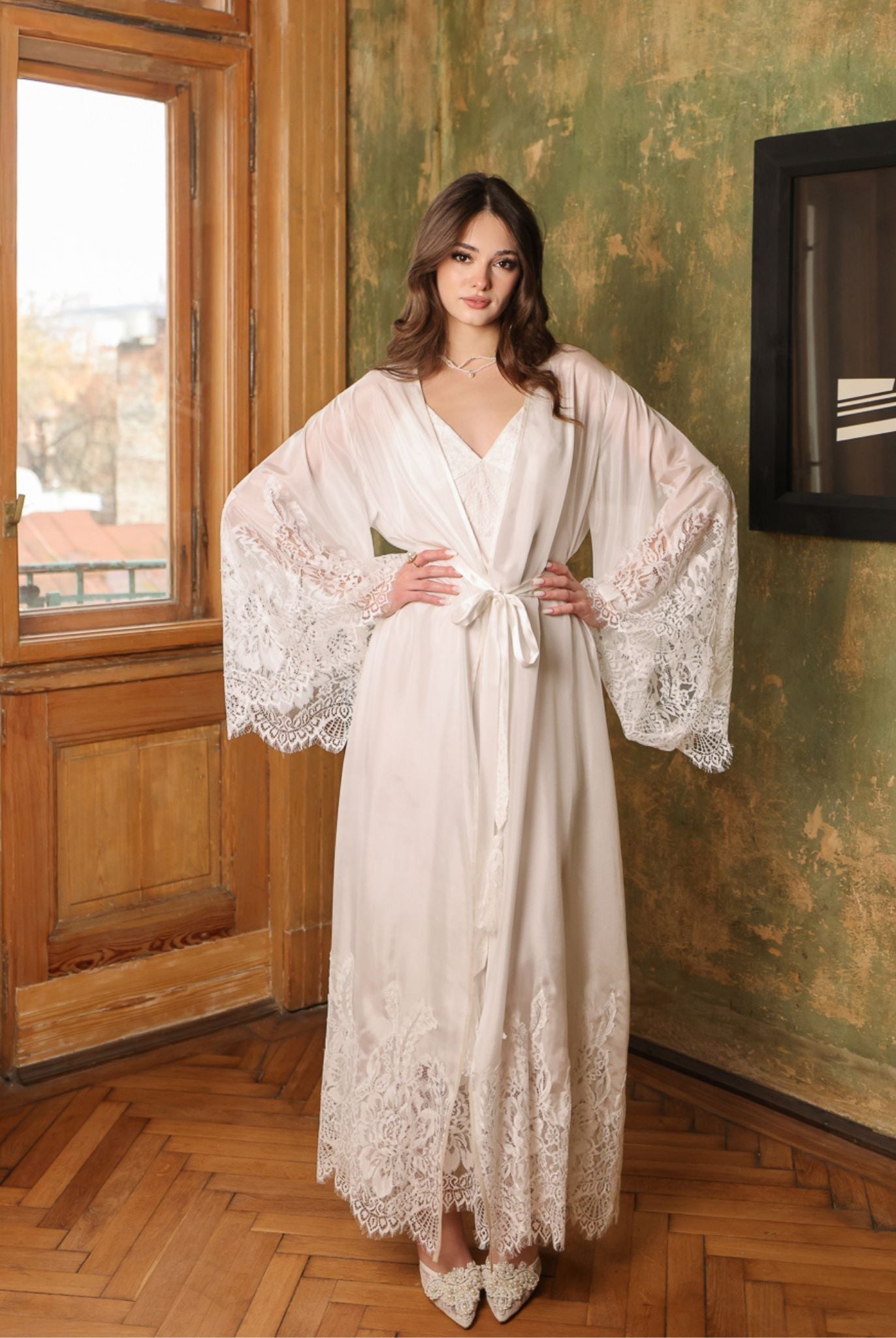 Frontal pose with hands on hips, displaying the voluminous lace-adorned sleeves and the feminine silhouette.