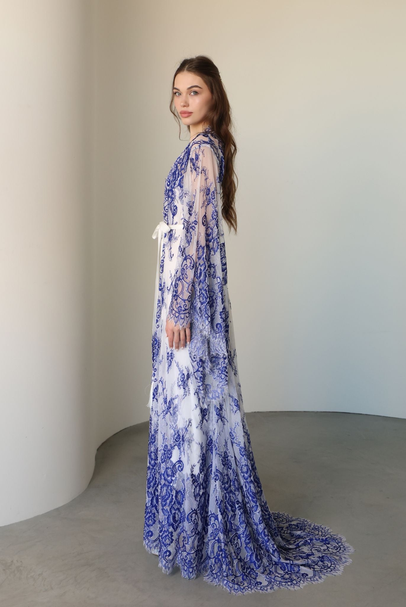 Side view focusing on the sweeping lace train and the delicate mix of materials designed for complete freedom.