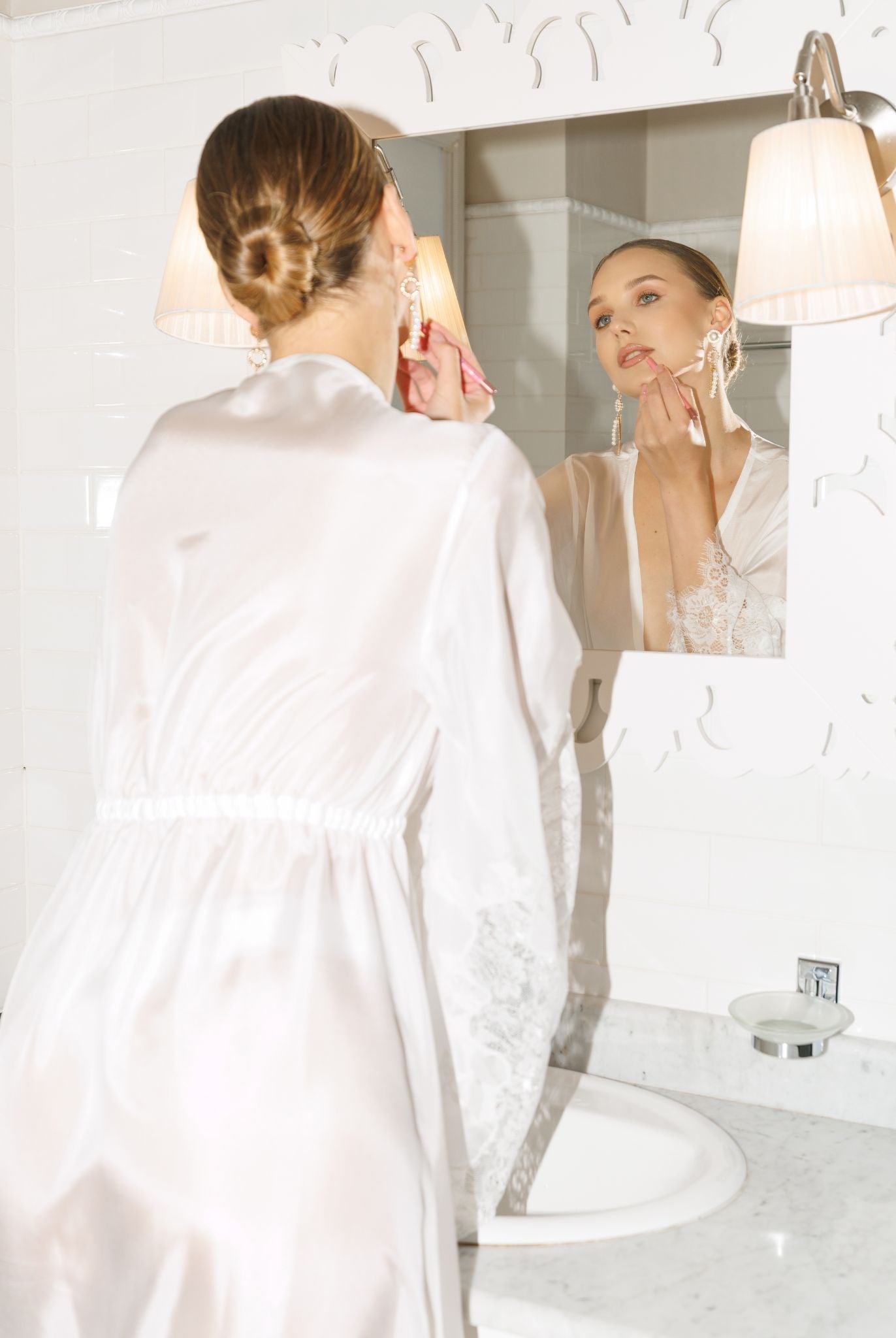 Back view of a sheer white silk robe for women, highlighting the flowing silhouette and delicate lace hem.