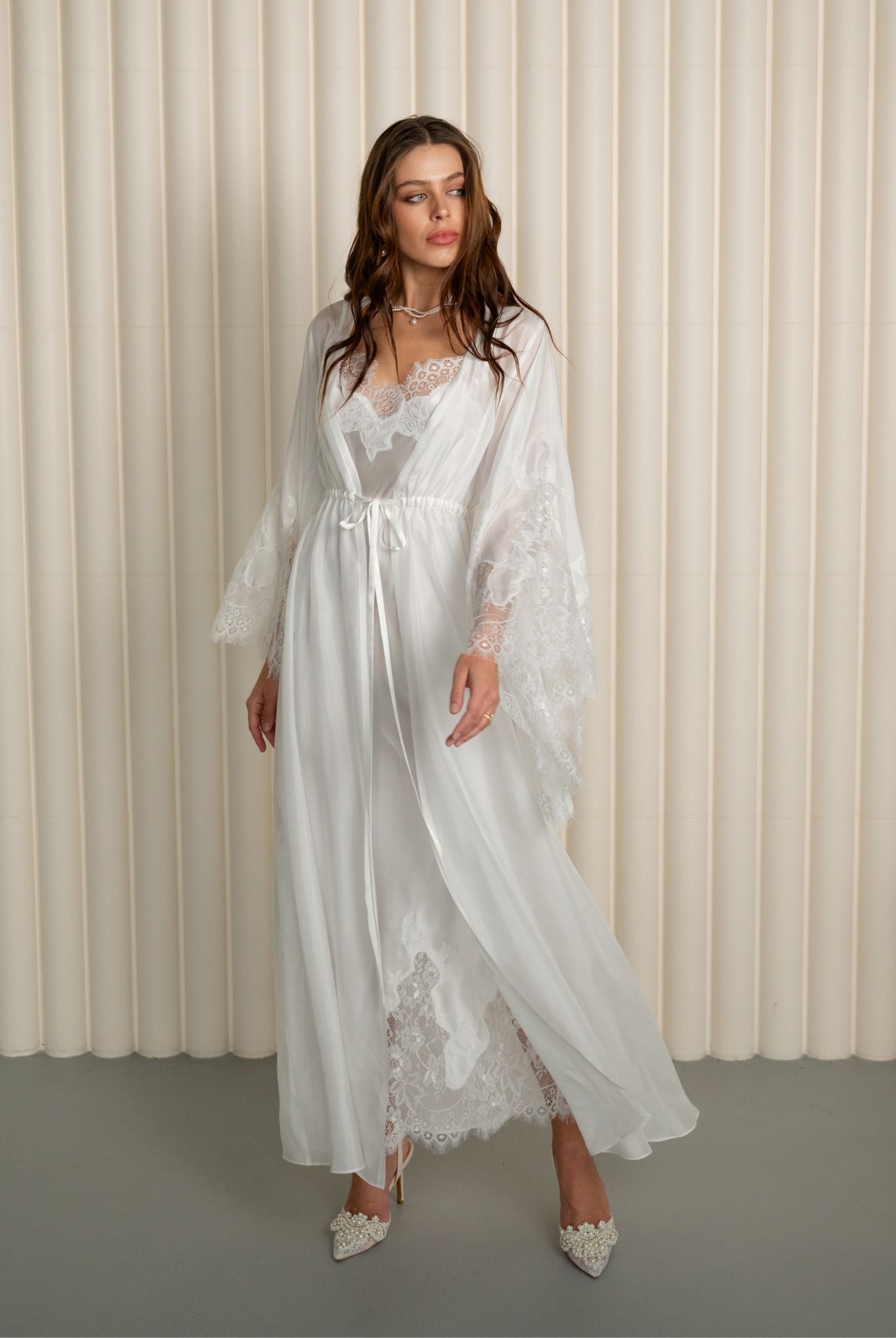 Woman wearing white silk robe over lace nightgown from Kafemme
