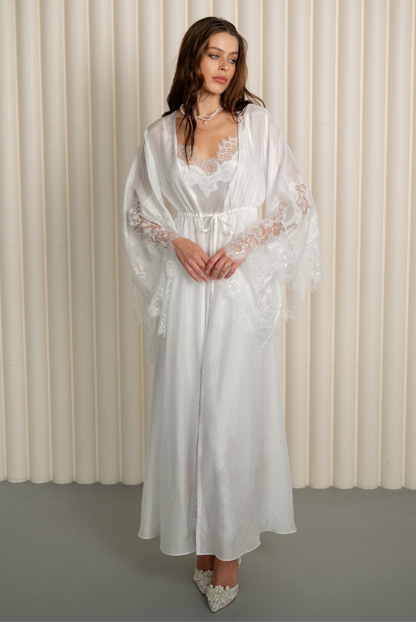 Woman in full-length white silk robe with lace by Kafemme