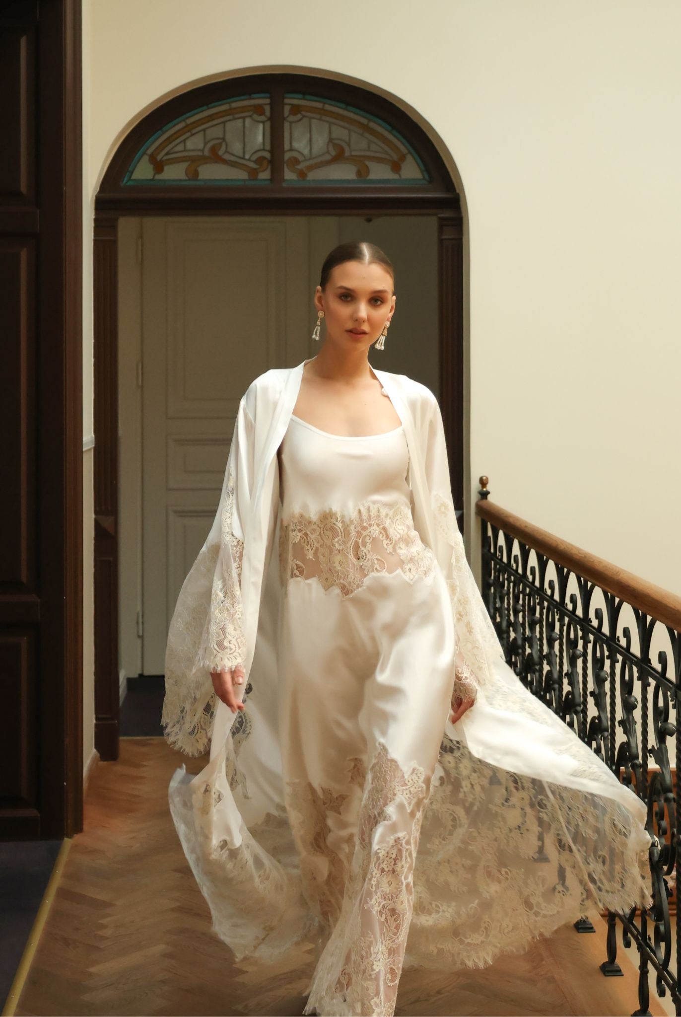 Dynamic shot of a white bridal ensemble in motion, capturing the ethereal elegance of the French lace design.