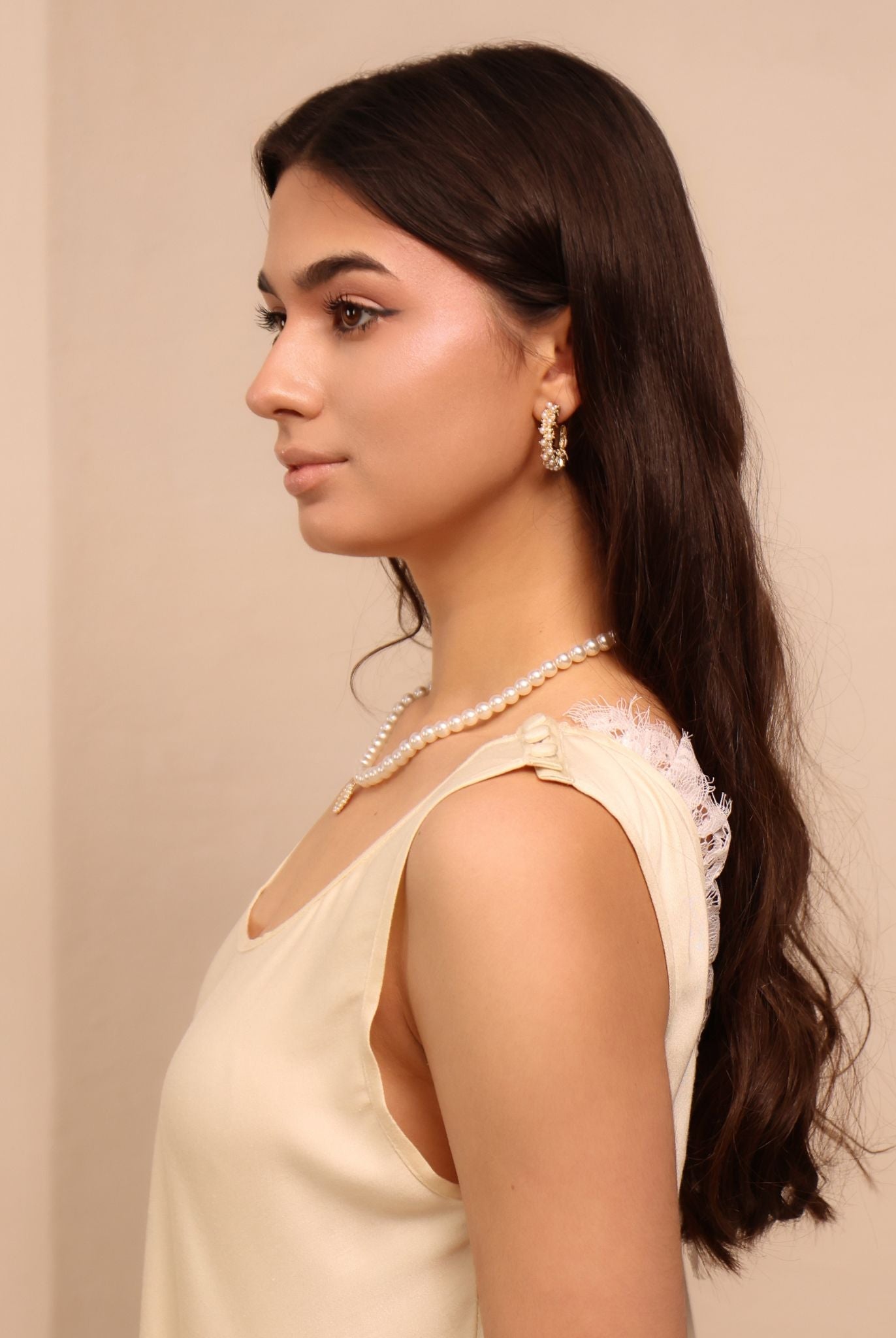 A close-up portrait focusing on the refined lace details and the practical shoulder buttons of the maternity set.