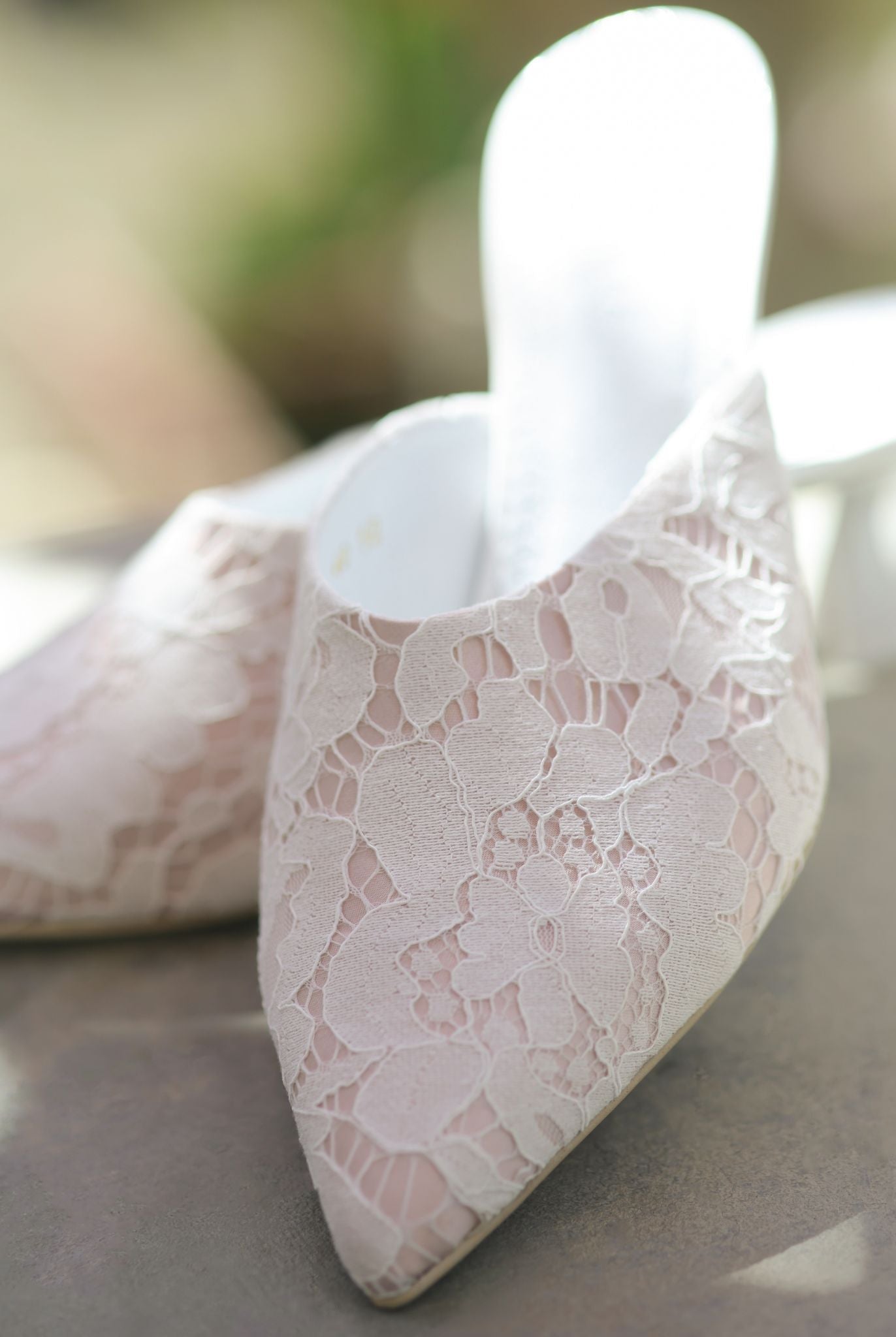 A static shot of the Satin Slippers on a balcony, highlighting the 5 cm heel and the luminous satin base.