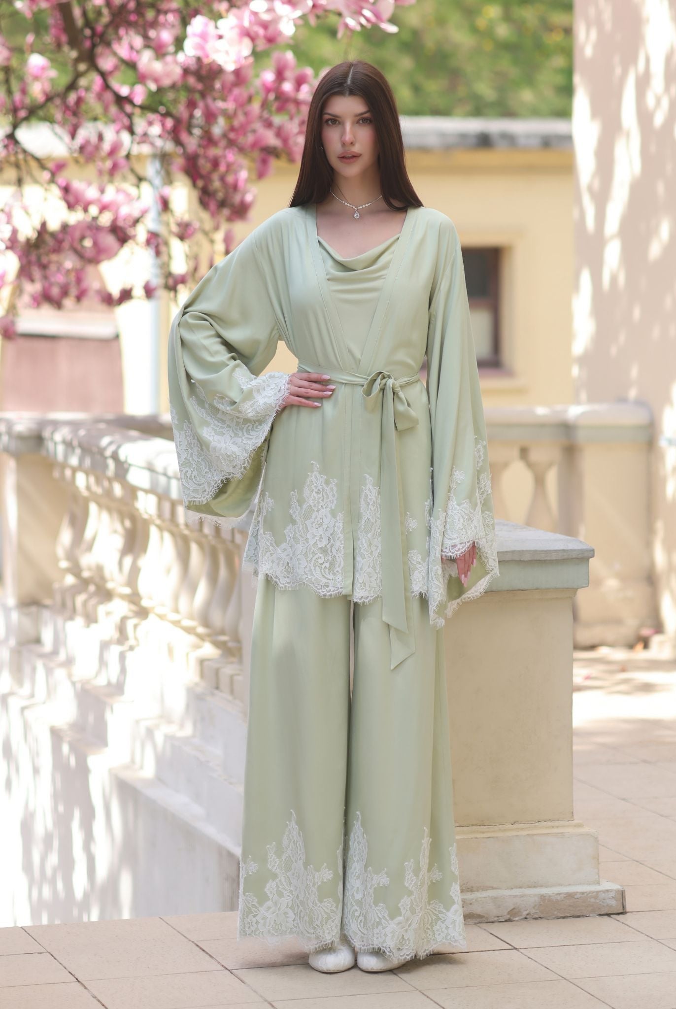 A poised view of the ensemble with one hand on the waist, showcasing the sophisticated drama of the kimono sleeves.