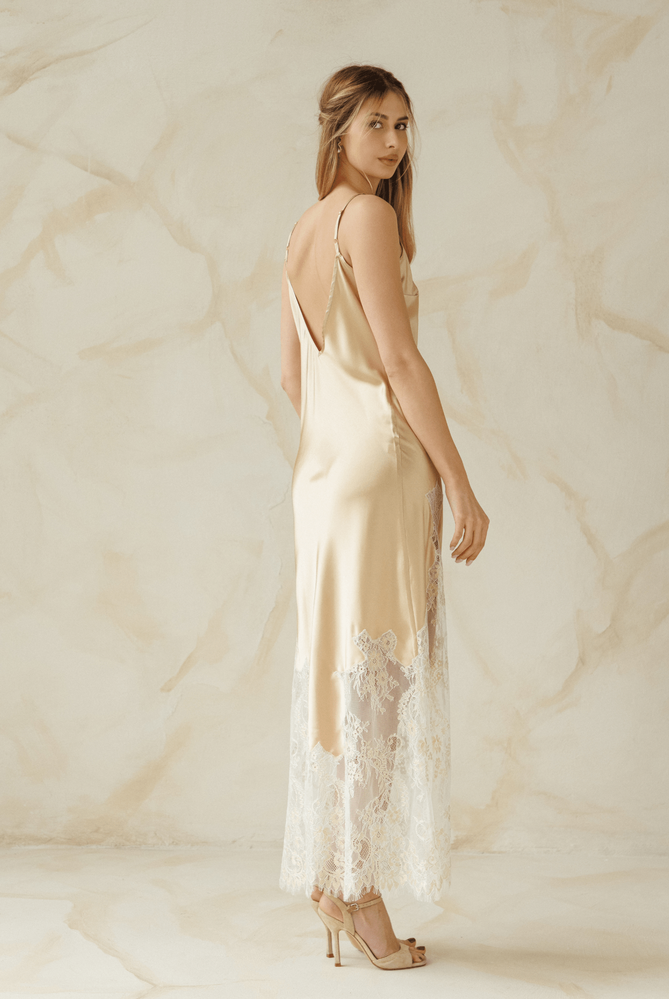 Back view of a beige nightgown with slim straps and soft lace detail