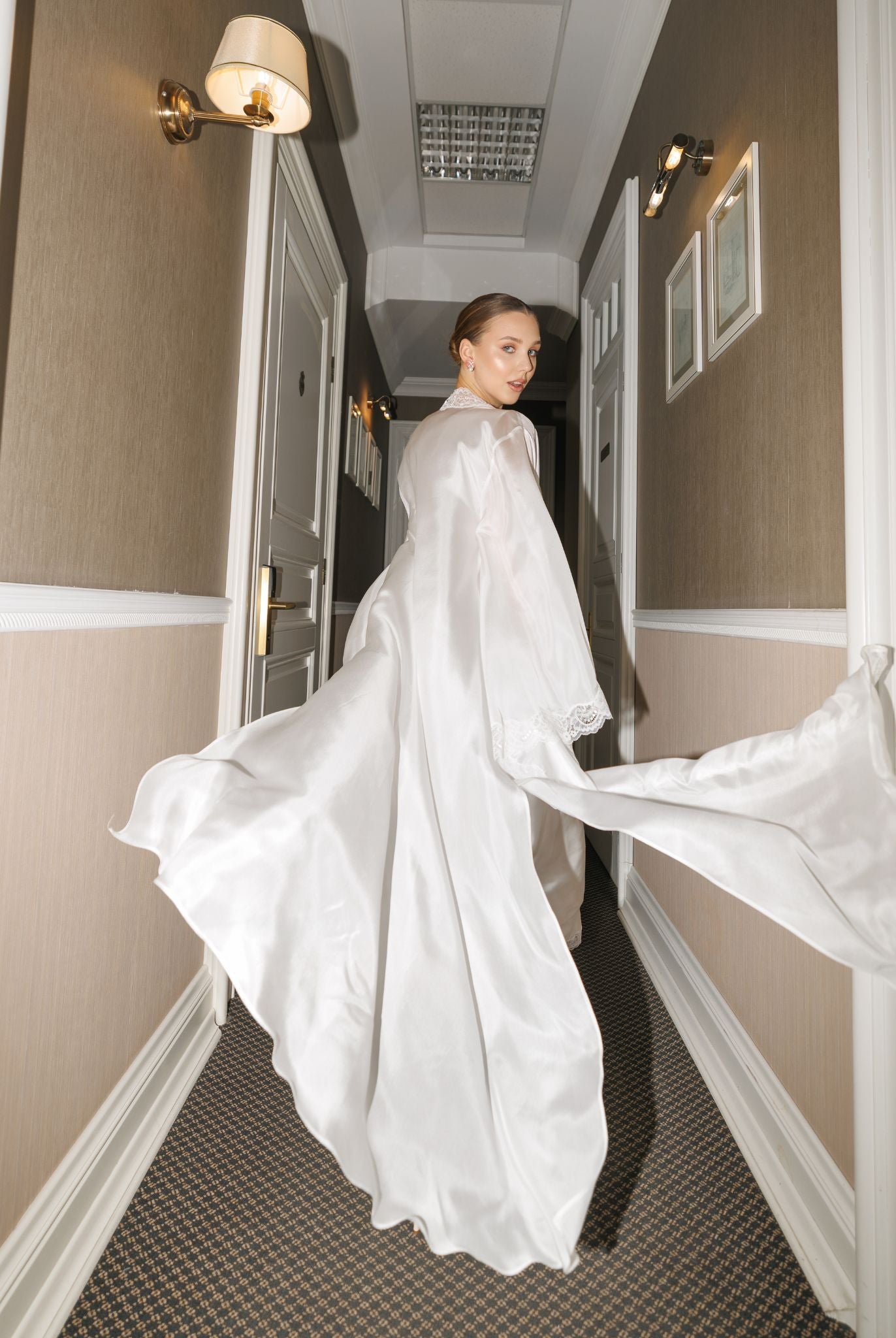 Creative shot of a woman running through a corridor, featuring the flowing semi-sheer silk habotai robe in motion.