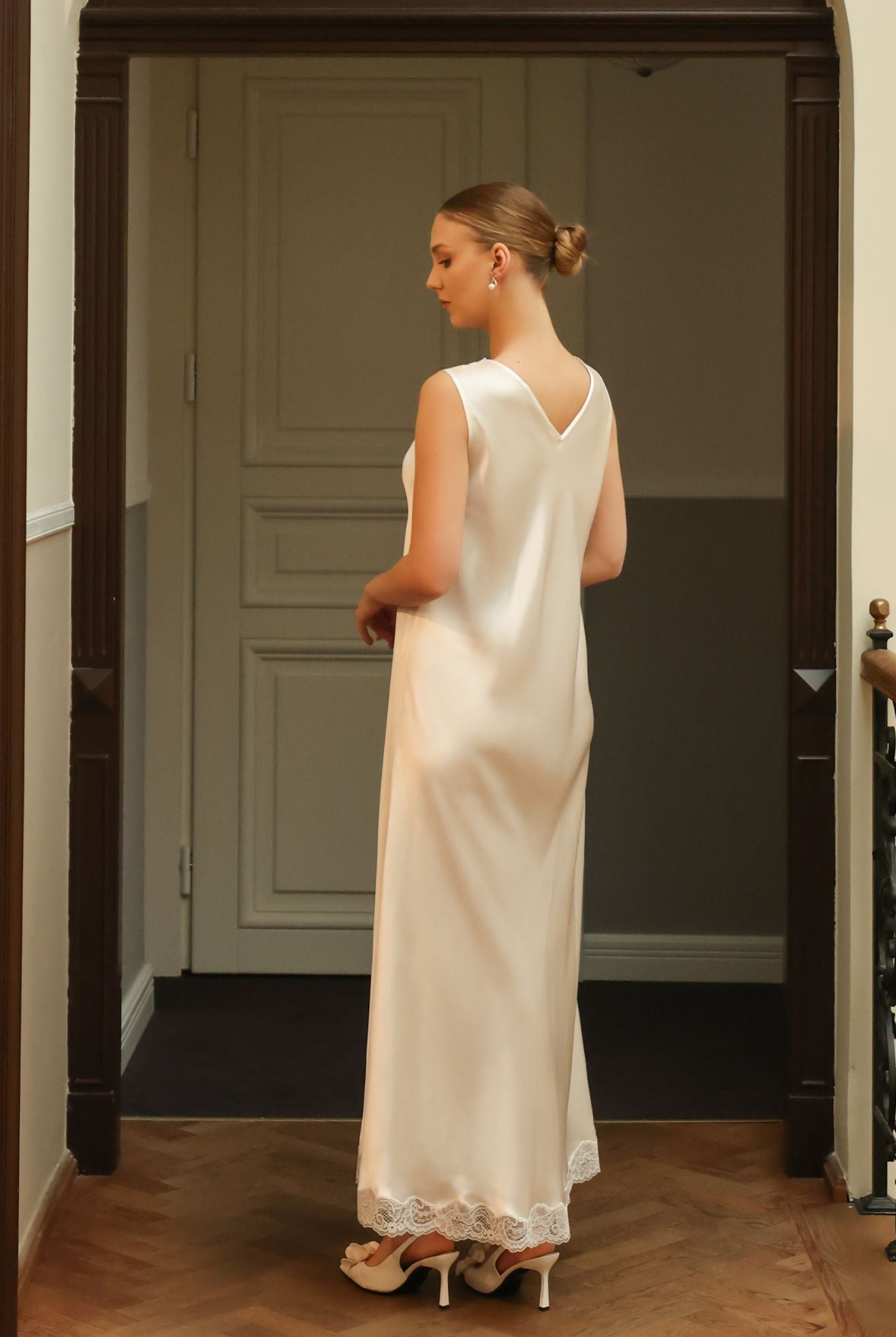 Rear view of a silk satin nightgown, focusing on the conservative V-cut back adorned with delicate floral lace patterns.
