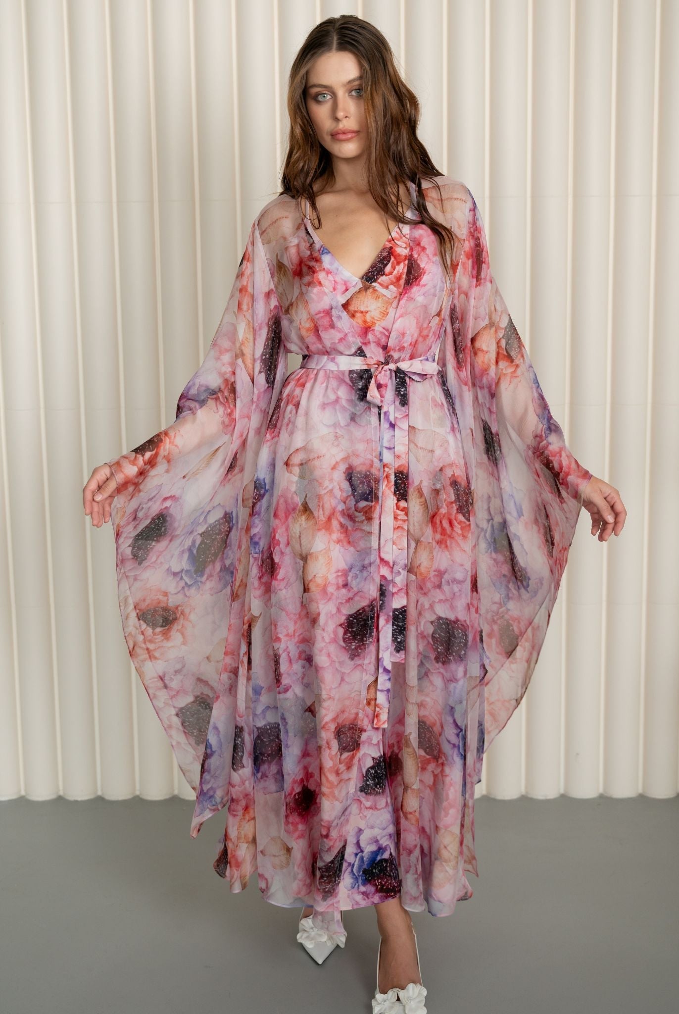 Front view with slightly raised arms to display the artistic floral design and structural cut of the silk sleeves.