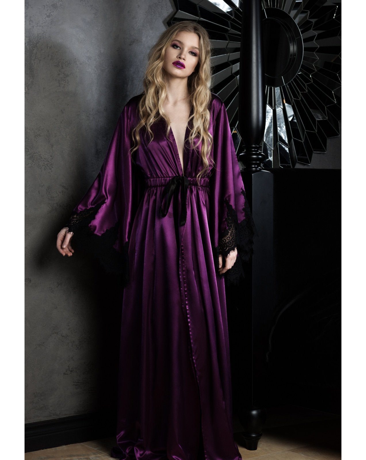 A full-length standing pose illustrating the tall, powerful silhouette and the sweeping hem of the silk ensemble.