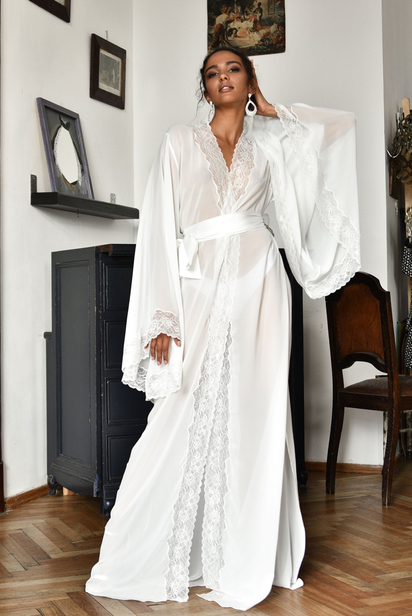 Woman wearing a flowing chiffon robe standing next to a piano