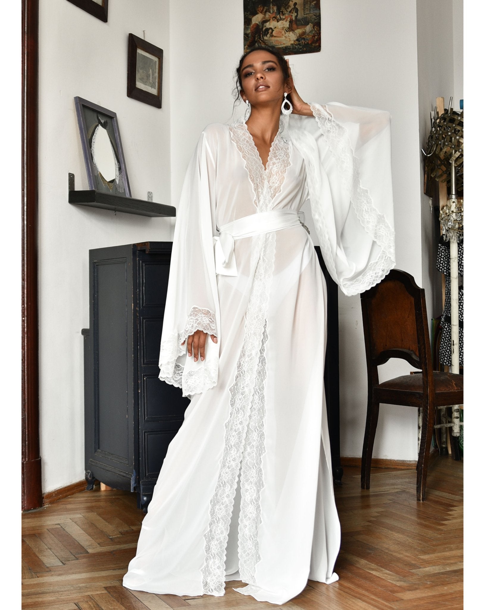 Woman wearing a flowing chiffon robe standing next to a piano